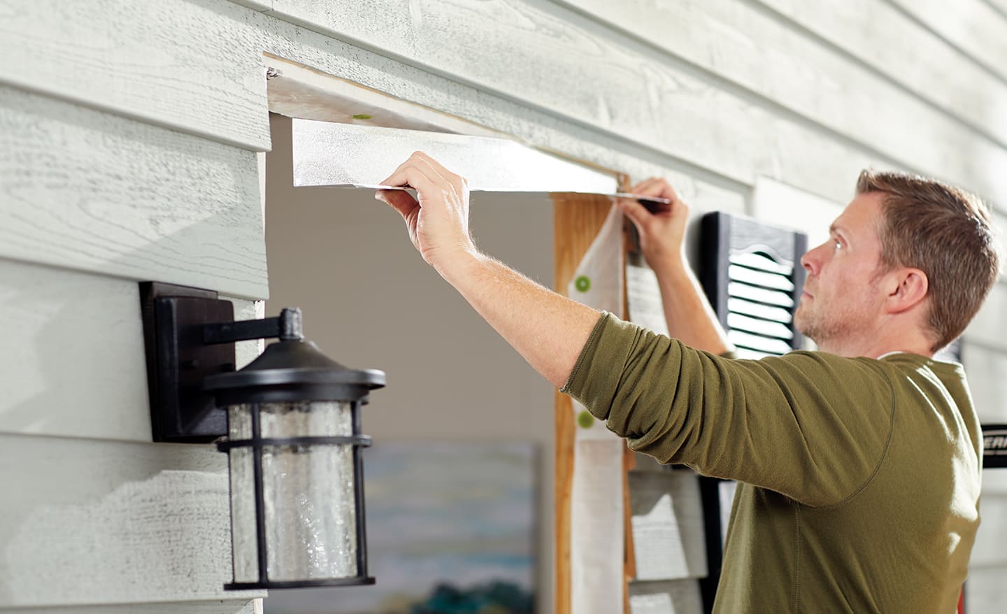 A man adjusting the moulding on the frame of a home entryway.