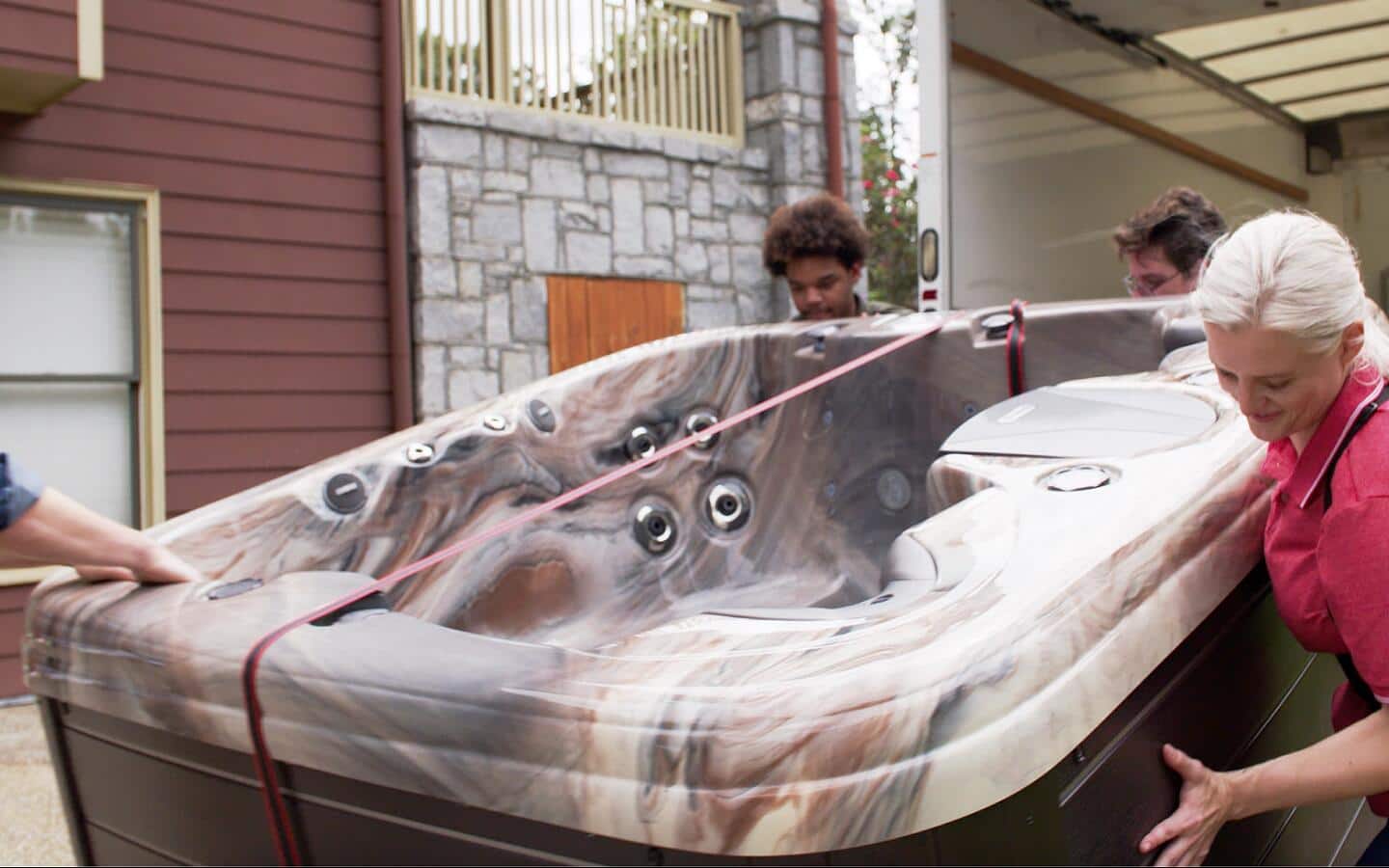 People unloading a hot tub from a truck.