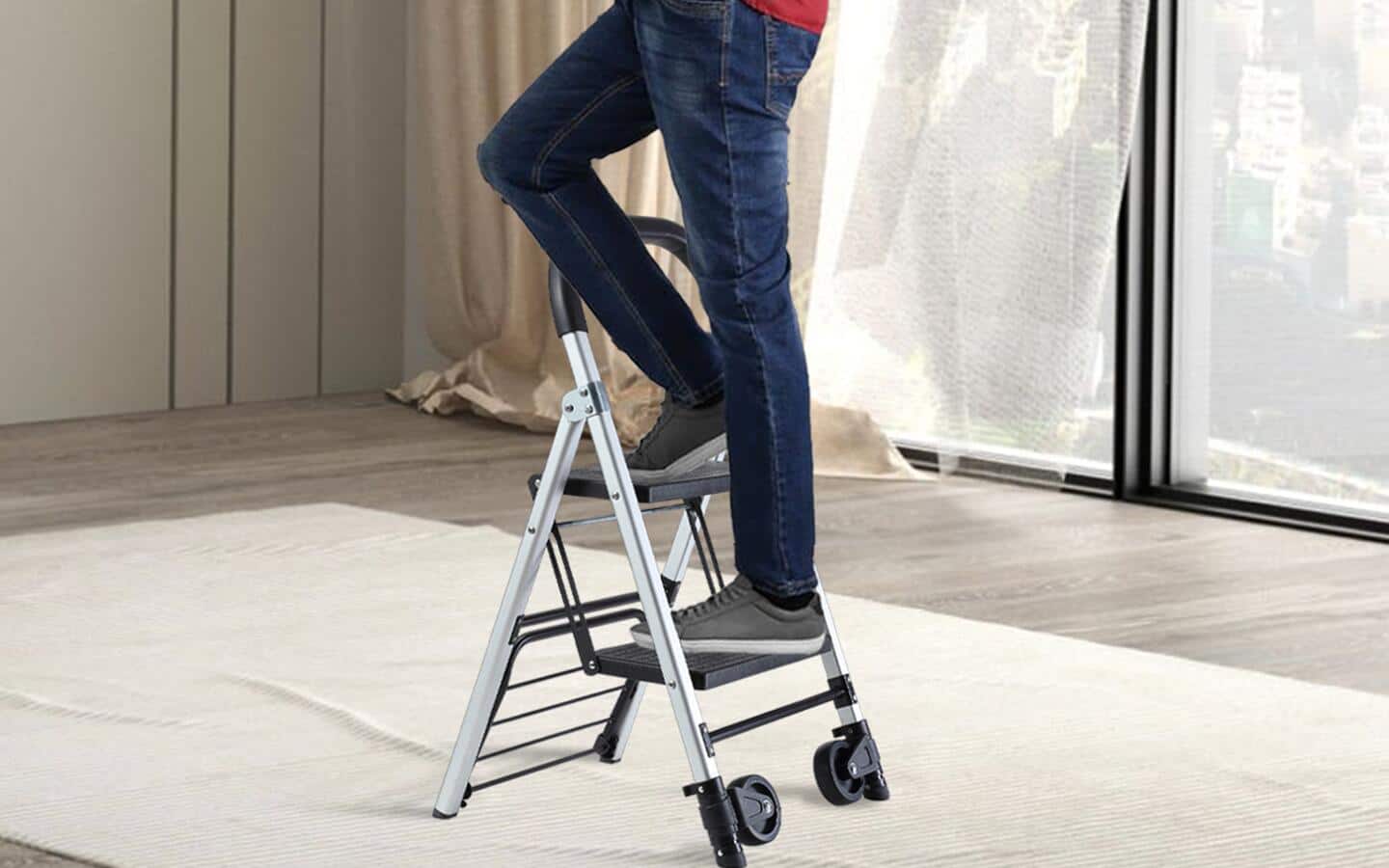 A person stands on a stepladder that is set up on a drop cloth.