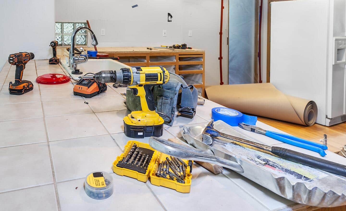 A collection of tools in a room in the early stage of cabinet installation.