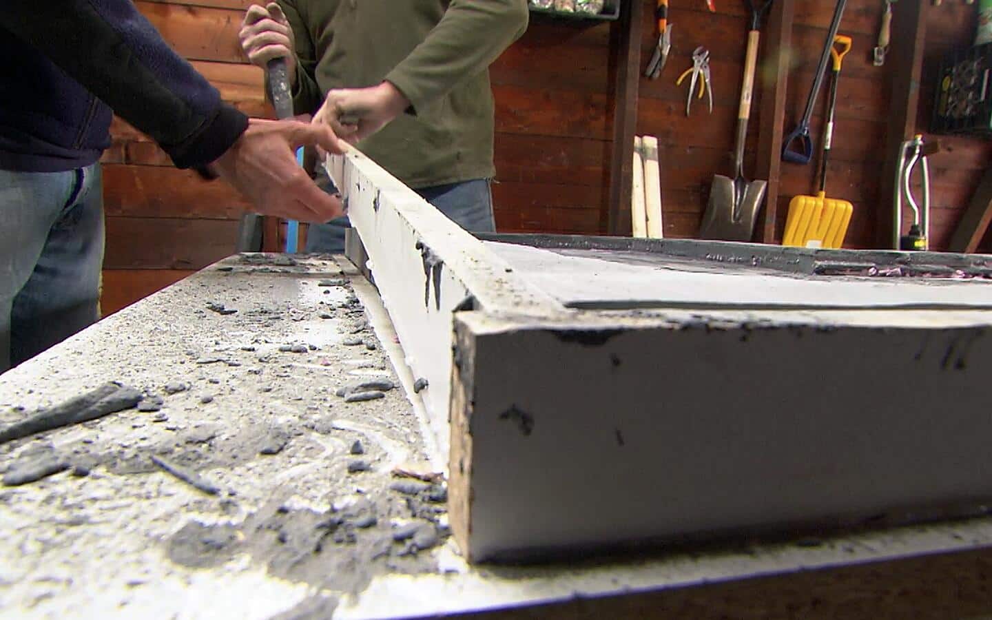 Two people removes a form to release the concrete countertop. Two people removes a form to release the concrete countertop.