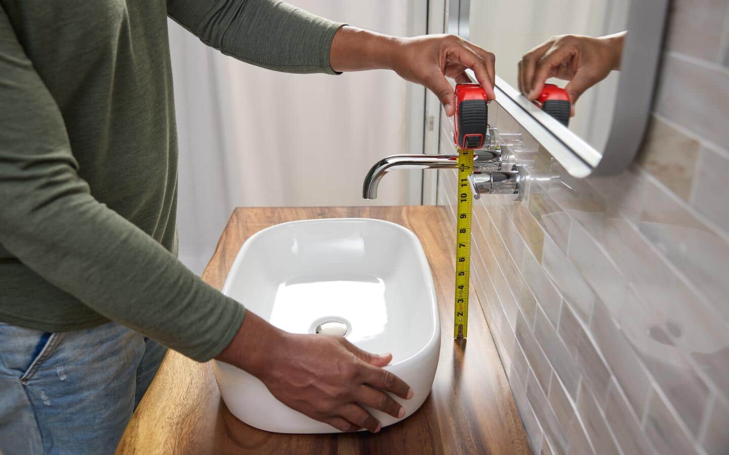 Measuring the heights of a wall mounted bathroom faucet.