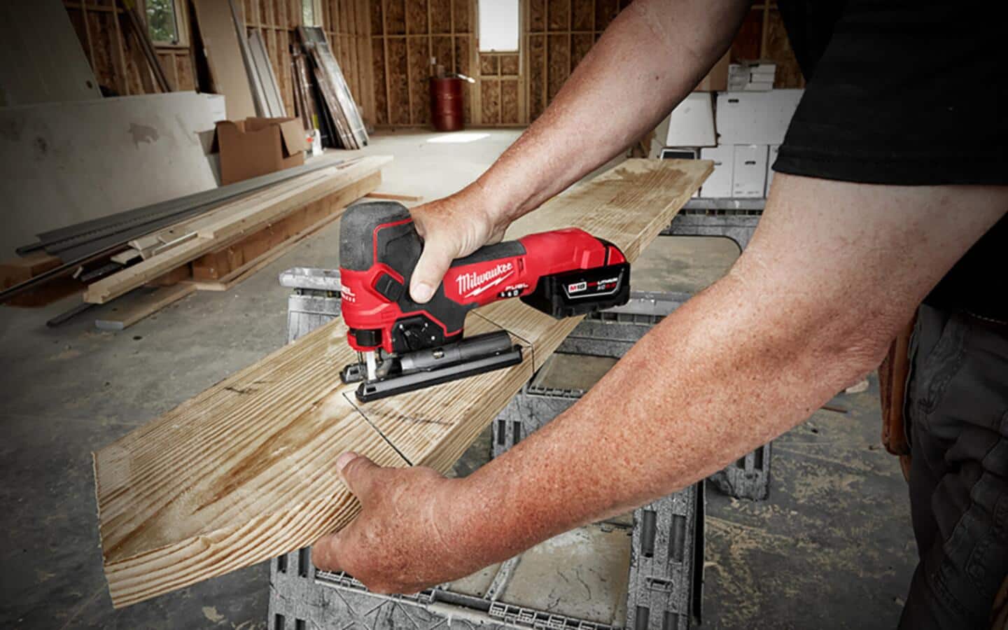 A man finishes a stair stringer cut with a barrel grip jigsaw. A man finishes a stair stringer cut with a barrel grip jigsaw.