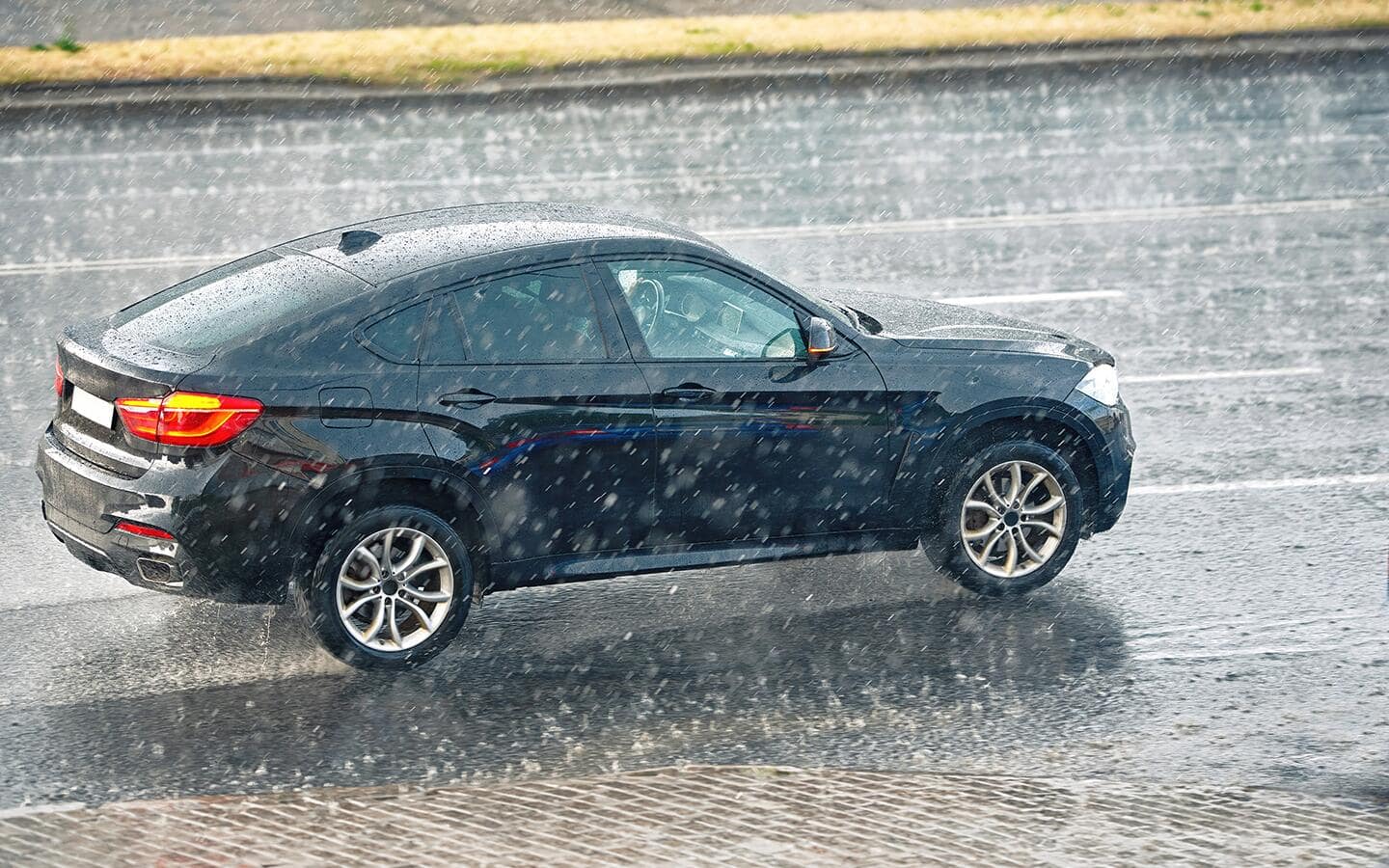A car driving on a wet road in the rain. A car driving on a wet road in the rain.