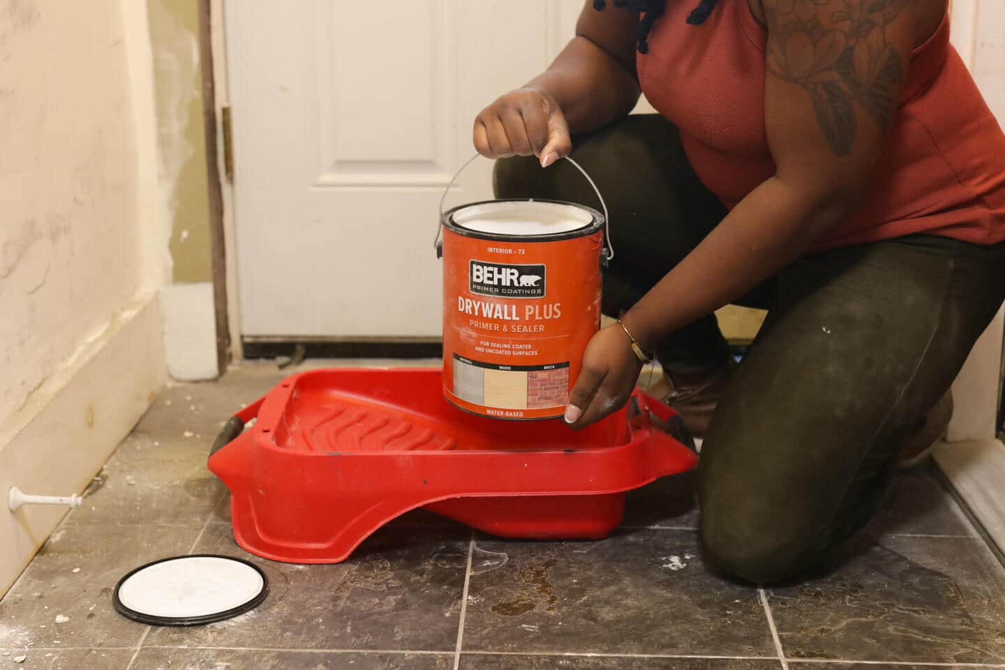 A person pouring paint into a tray.