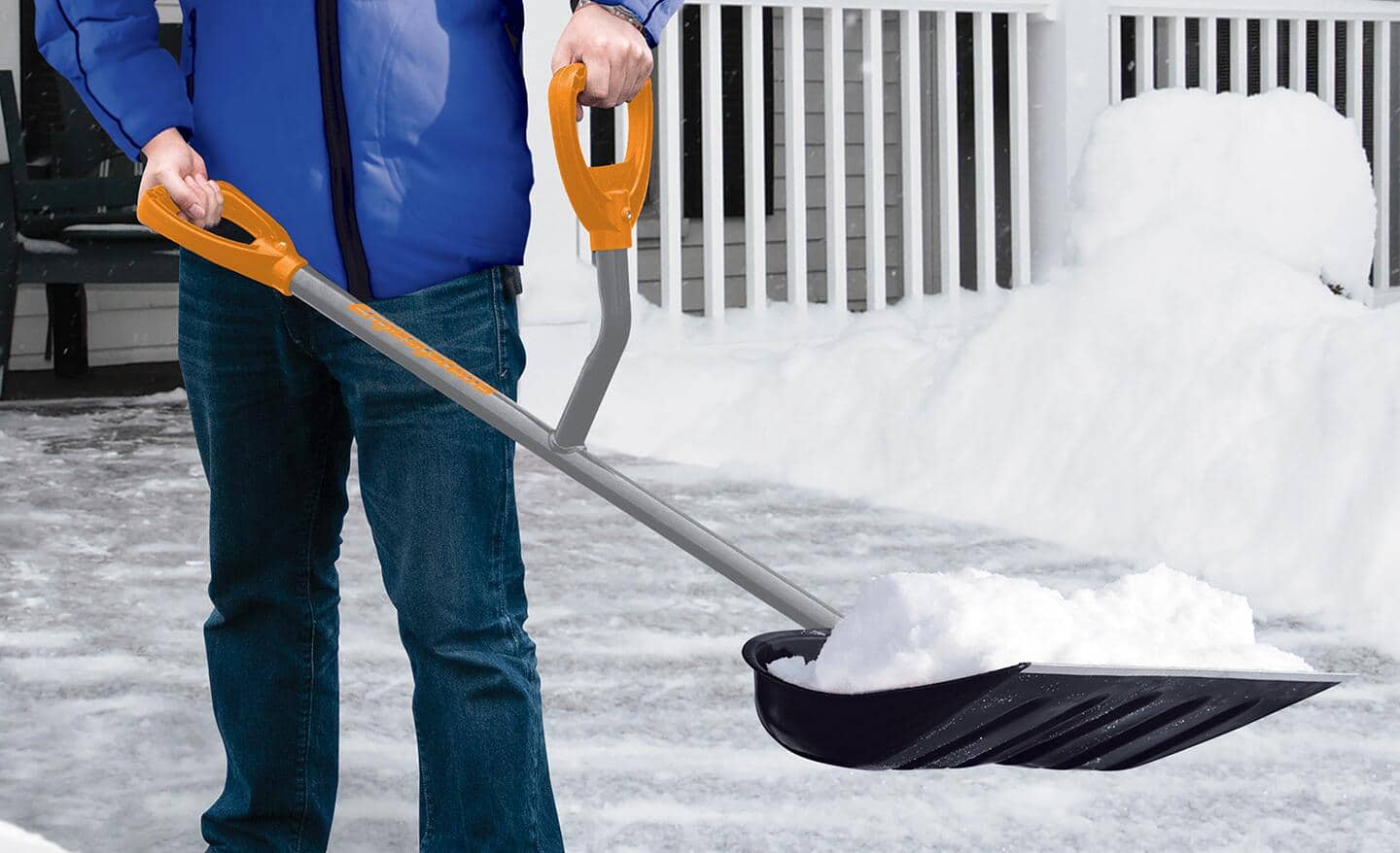 A person uses an ergonomic shovel to pick up snow. A person uses an ergonomic shovel to pick up snow.
