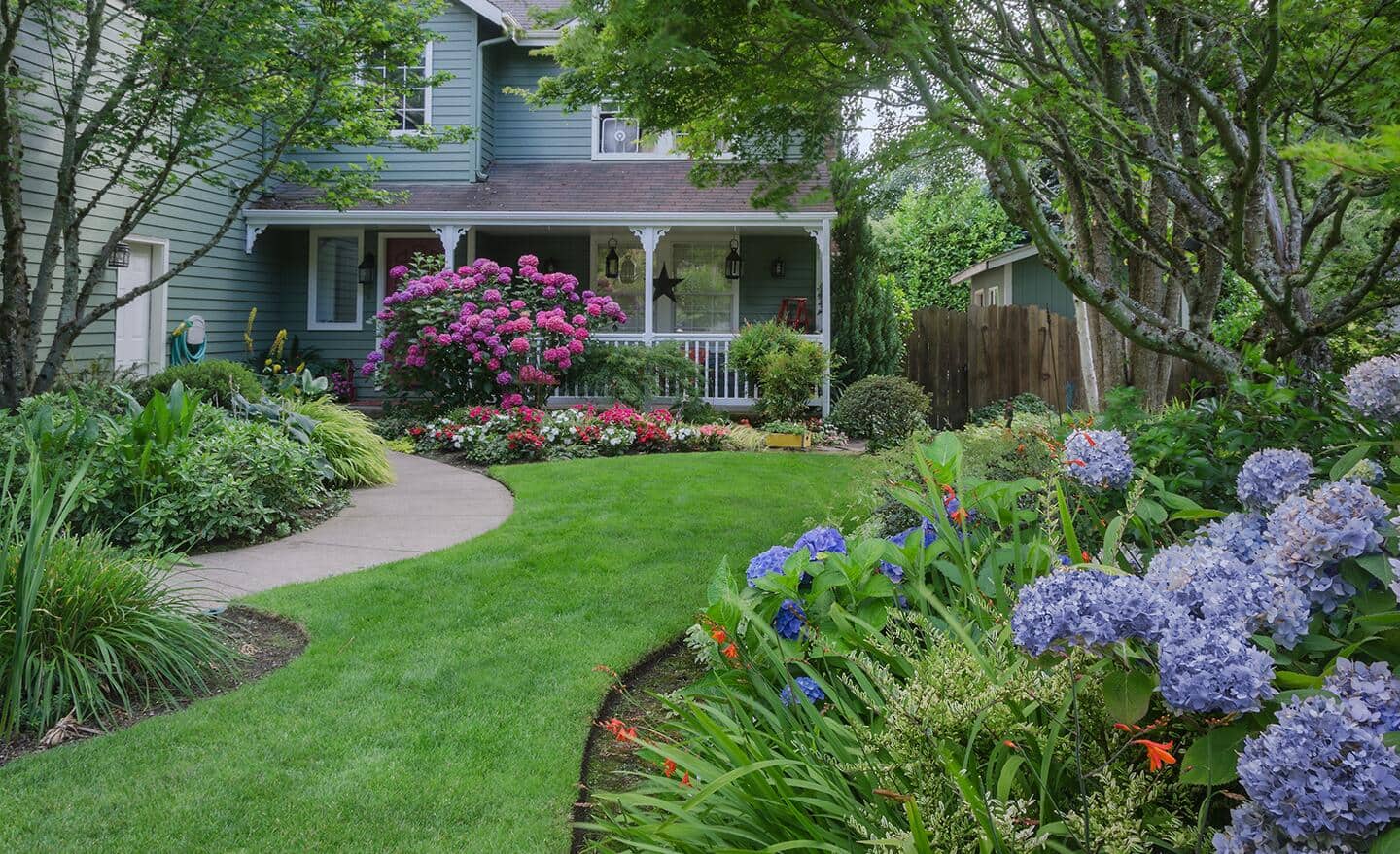 A suburban home with flowers and plants.