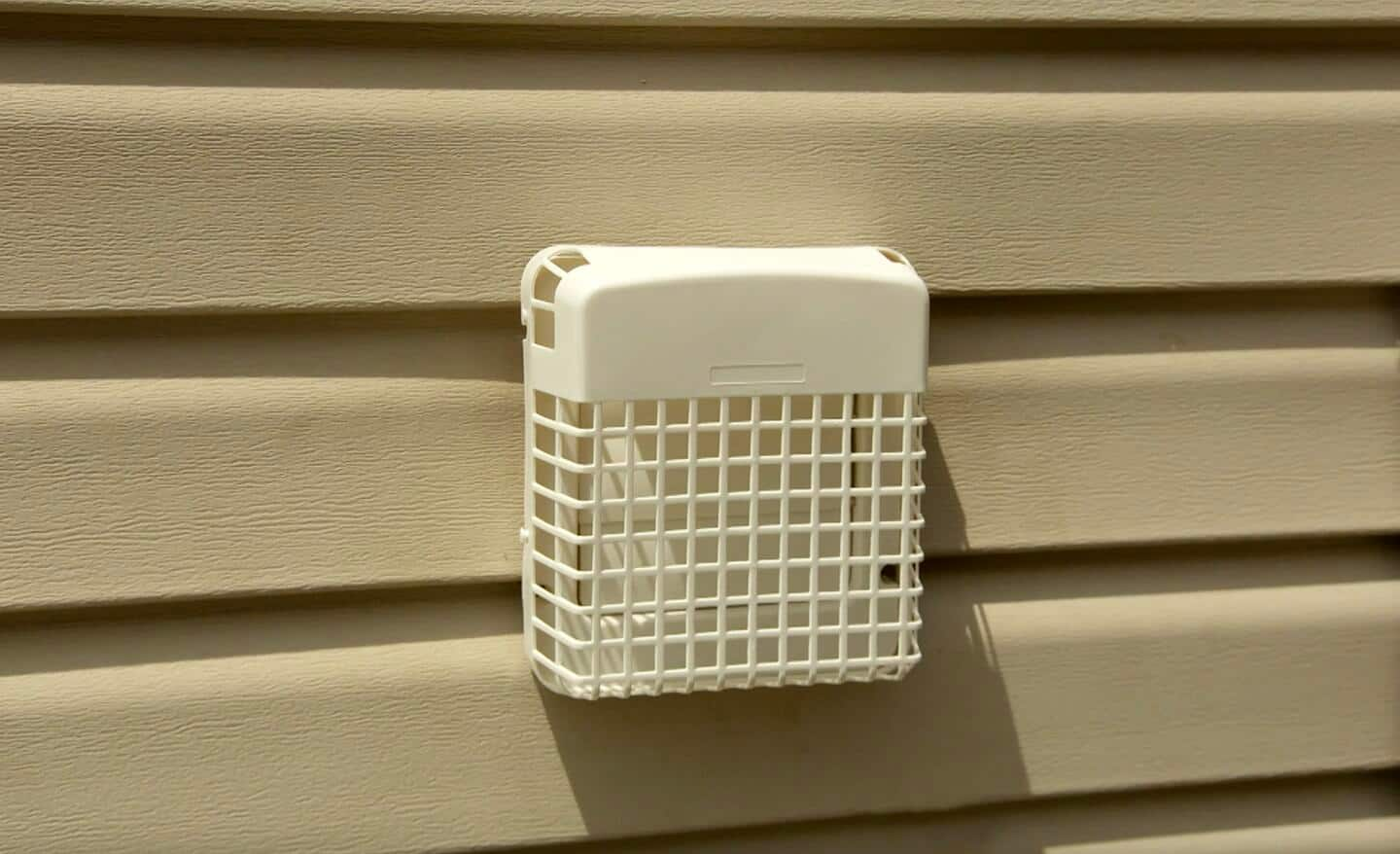 A dryer vent installed on the outside of a home.