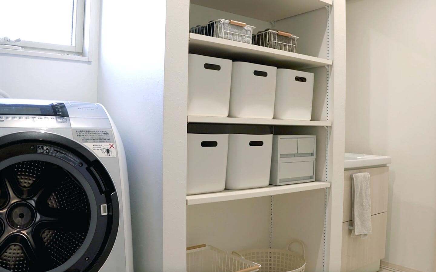 Various storage bins placed on shelves in a laundry room. Various storage bins placed on shelves in a laundry room.