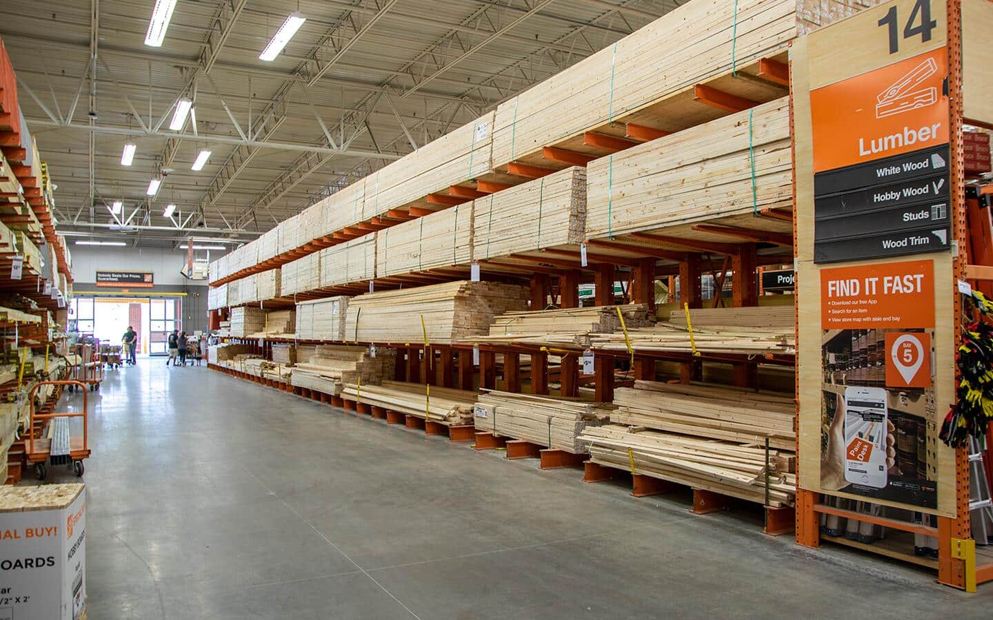 The Home Depot lumber aisle showing various board sizes.