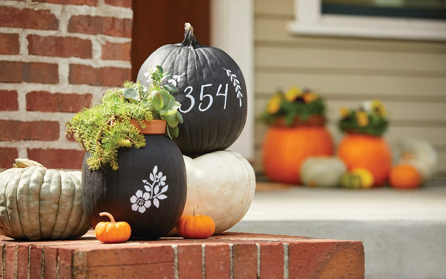 Fresh pumpkins painted with stenciled designs on a front porch Fresh pumpkins painted with stenciled designs on a front porch
