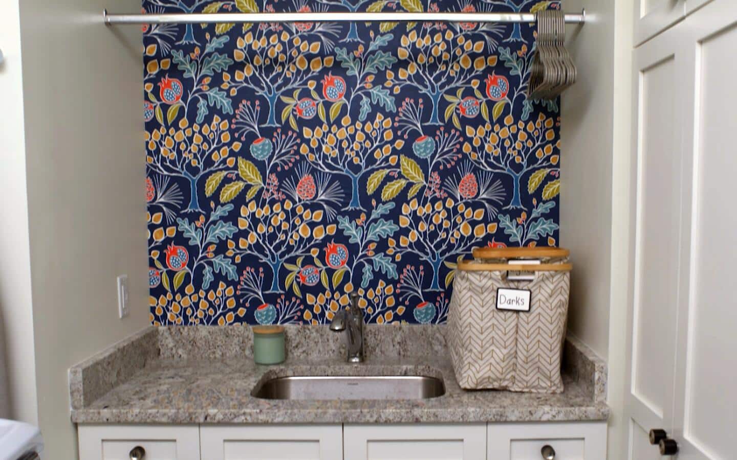 Colorful wallpaper on a wall behind a laundry sink. Colorful wallpaper on a wall behind a laundry sink.