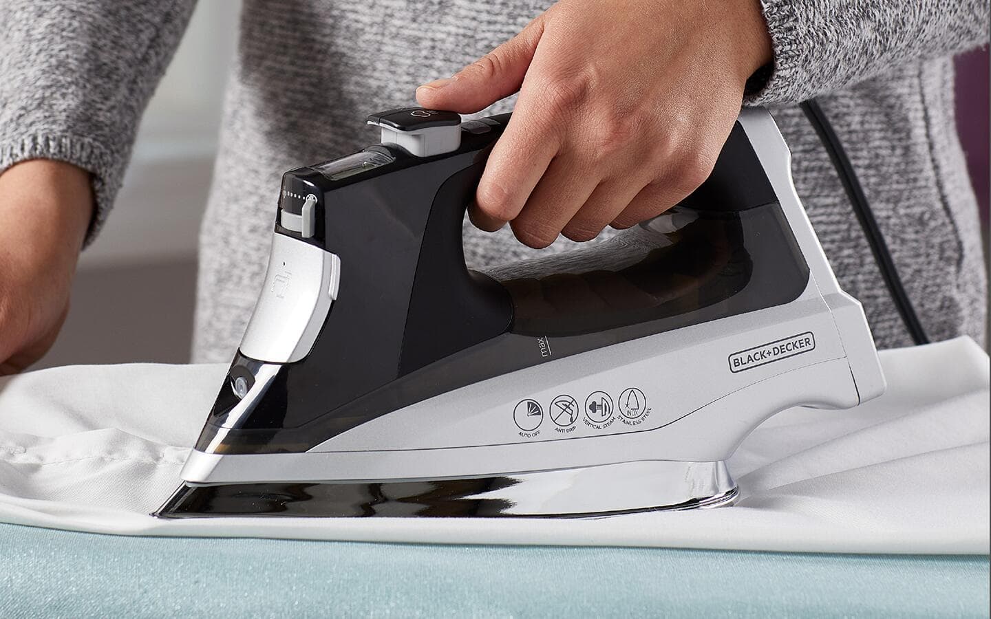 A black-and-white dry iron on an ironing board. A black-and-white dry iron on an ironing board.