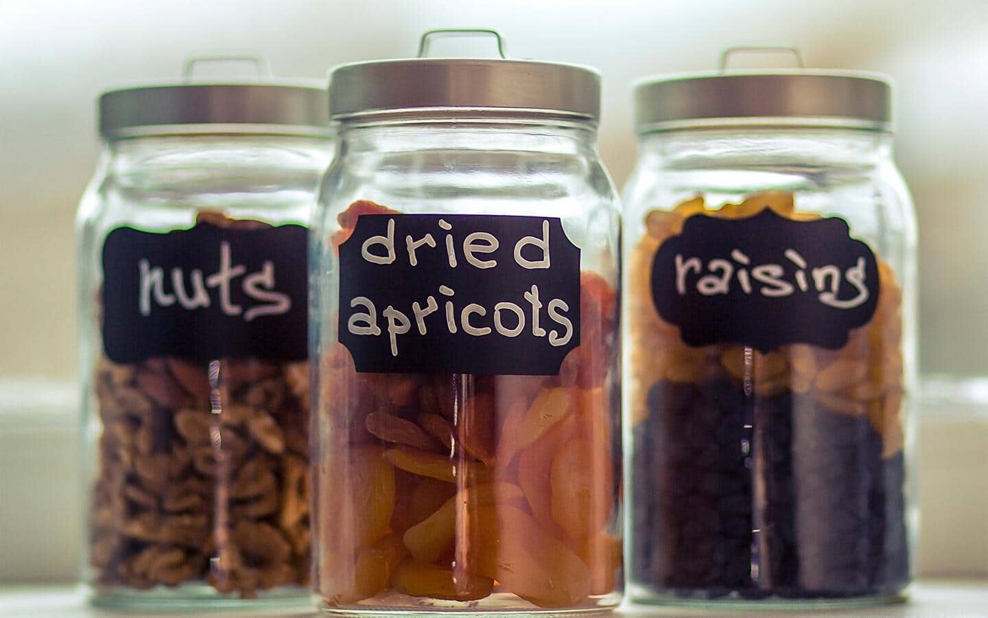 Large glass food containers with handwritten labels.