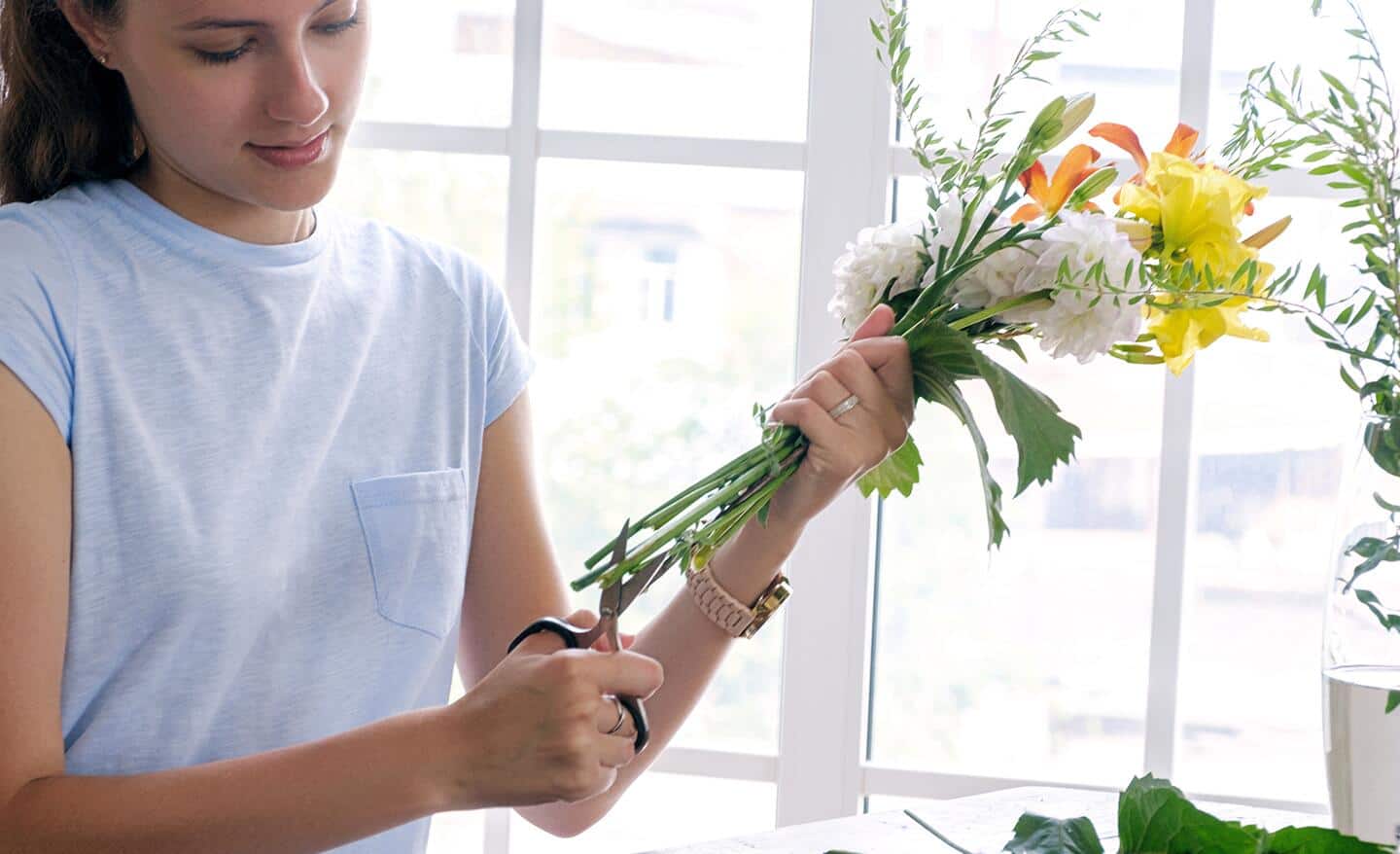 Person trims floral bouquet with floral scissors