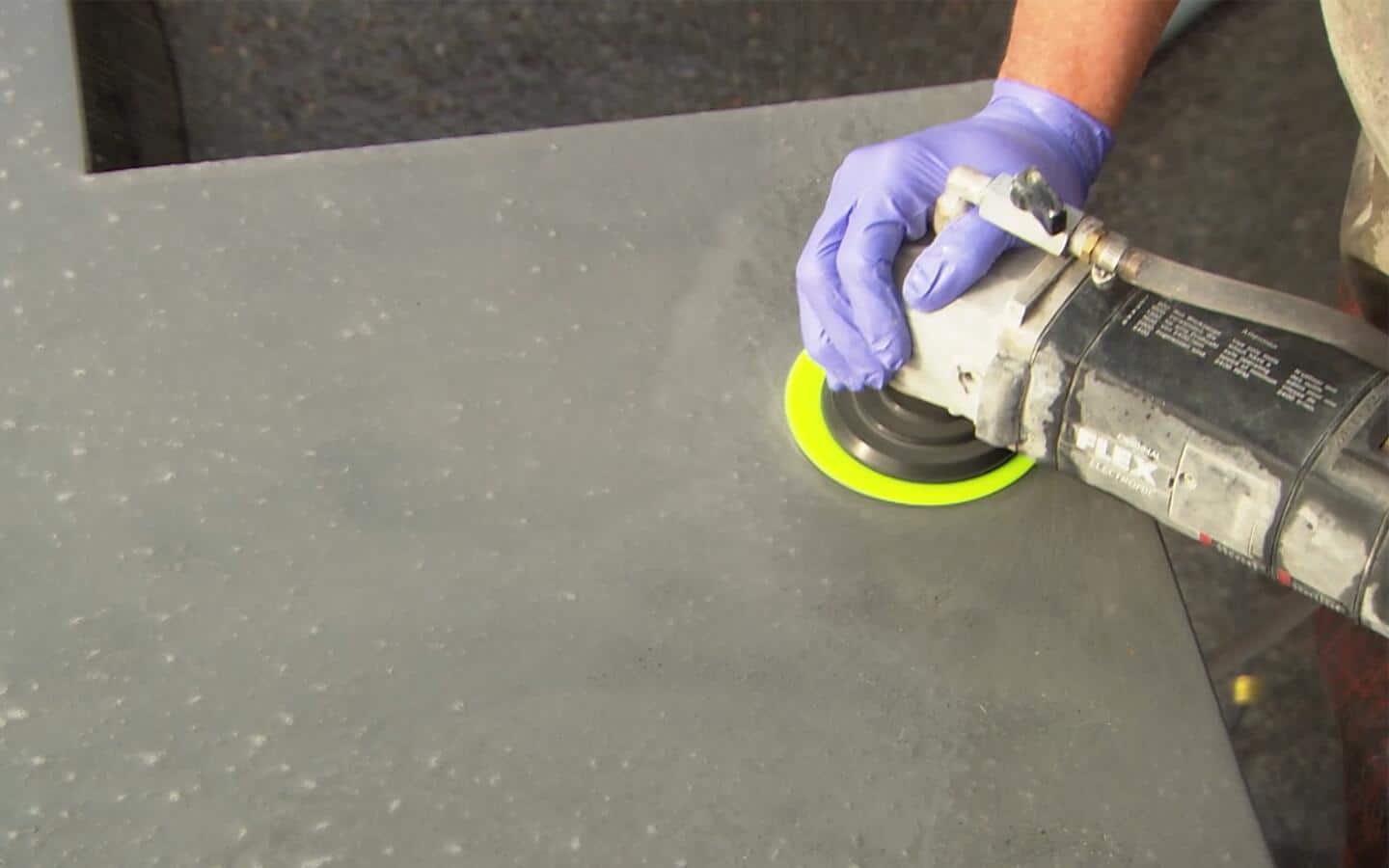 A person polishes a concrete countertop with a grinder. A person polishes a concrete countertop with a grinder.