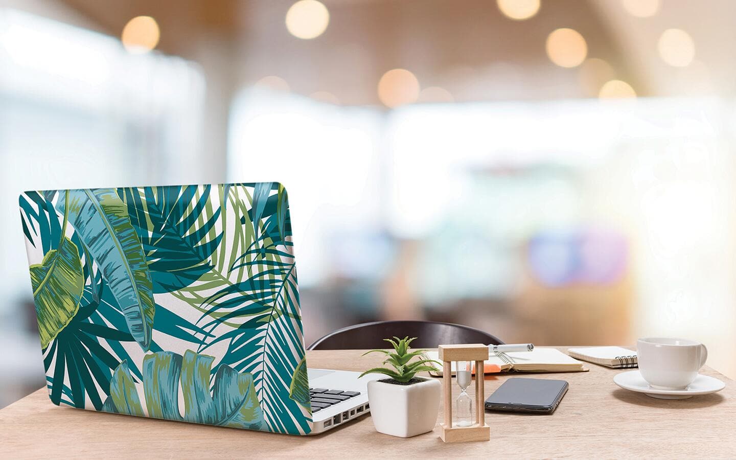 An open laptop shows off a top covered with botanical peel and stick wallpaper. An open laptop shows off a top covered with botanical peel and stick wallpaper.