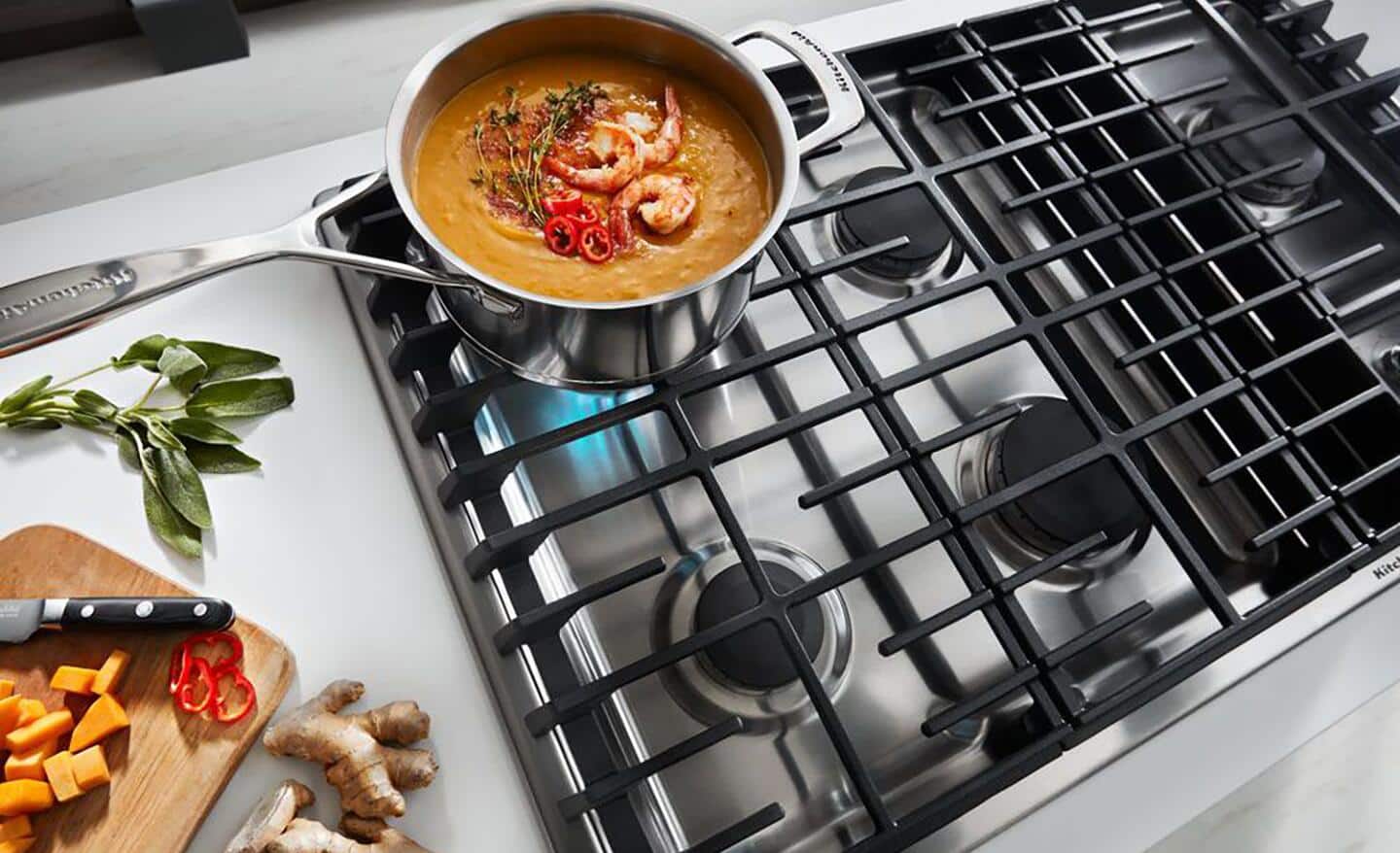 A downdraft stovetop heating up a pot filled with food. 