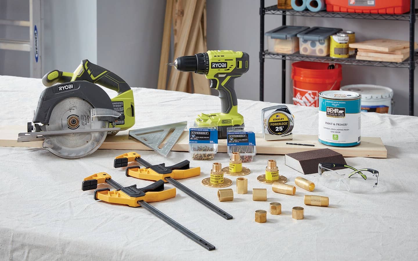 A saw, clamps, pipe pieces and other tools laid out to create a DY coat hanger.