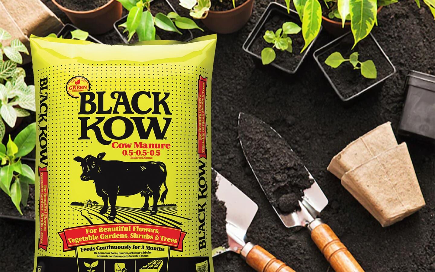 Packaged organic compost manure in a garden bed with tools and seedlings Packaged organic compost manure in a garden bed with tools and seedlings