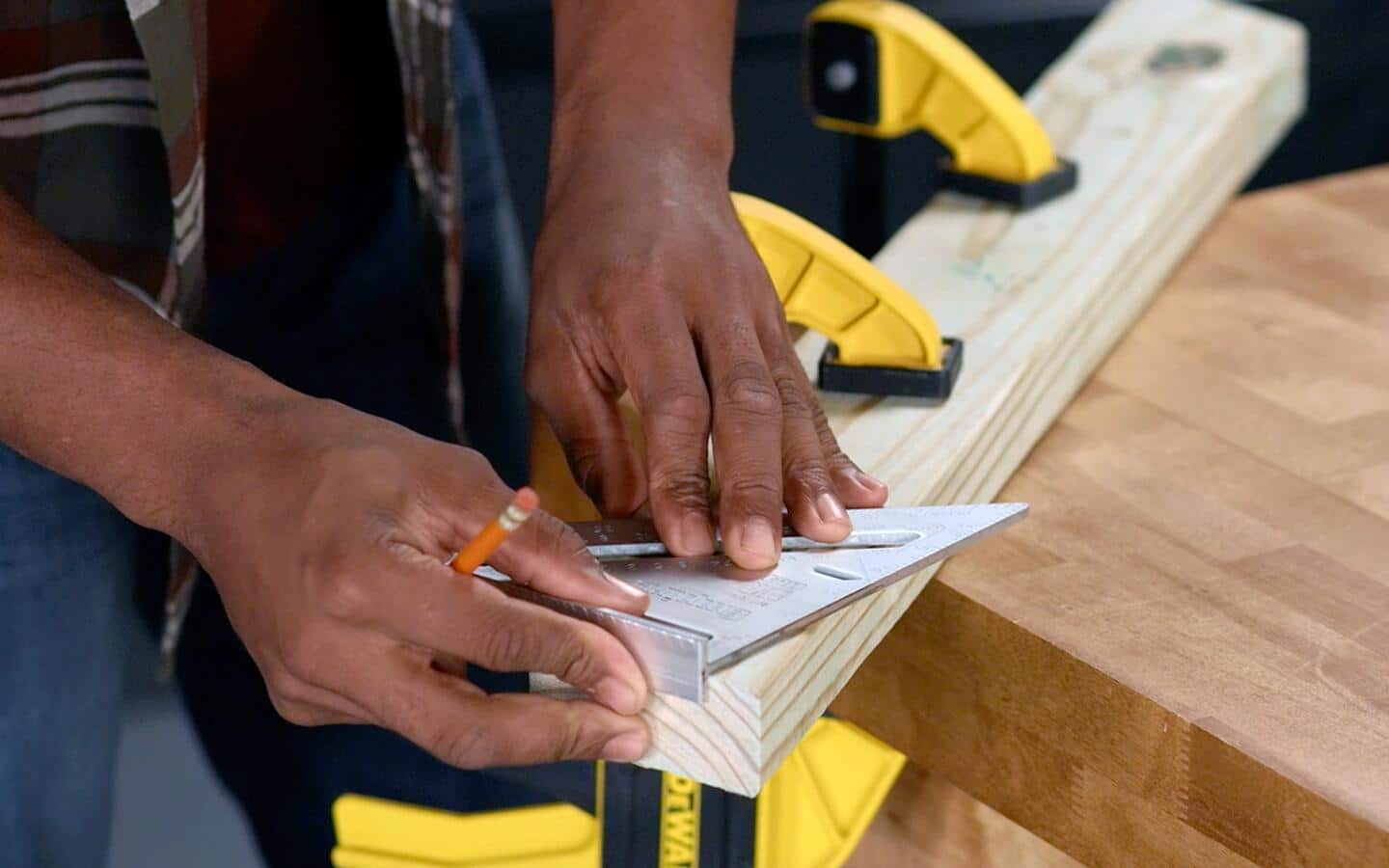 A person uses a speed square to measure an angle at a wood piece's end. A person uses a speed square to measure an angle at a wood piece's end.