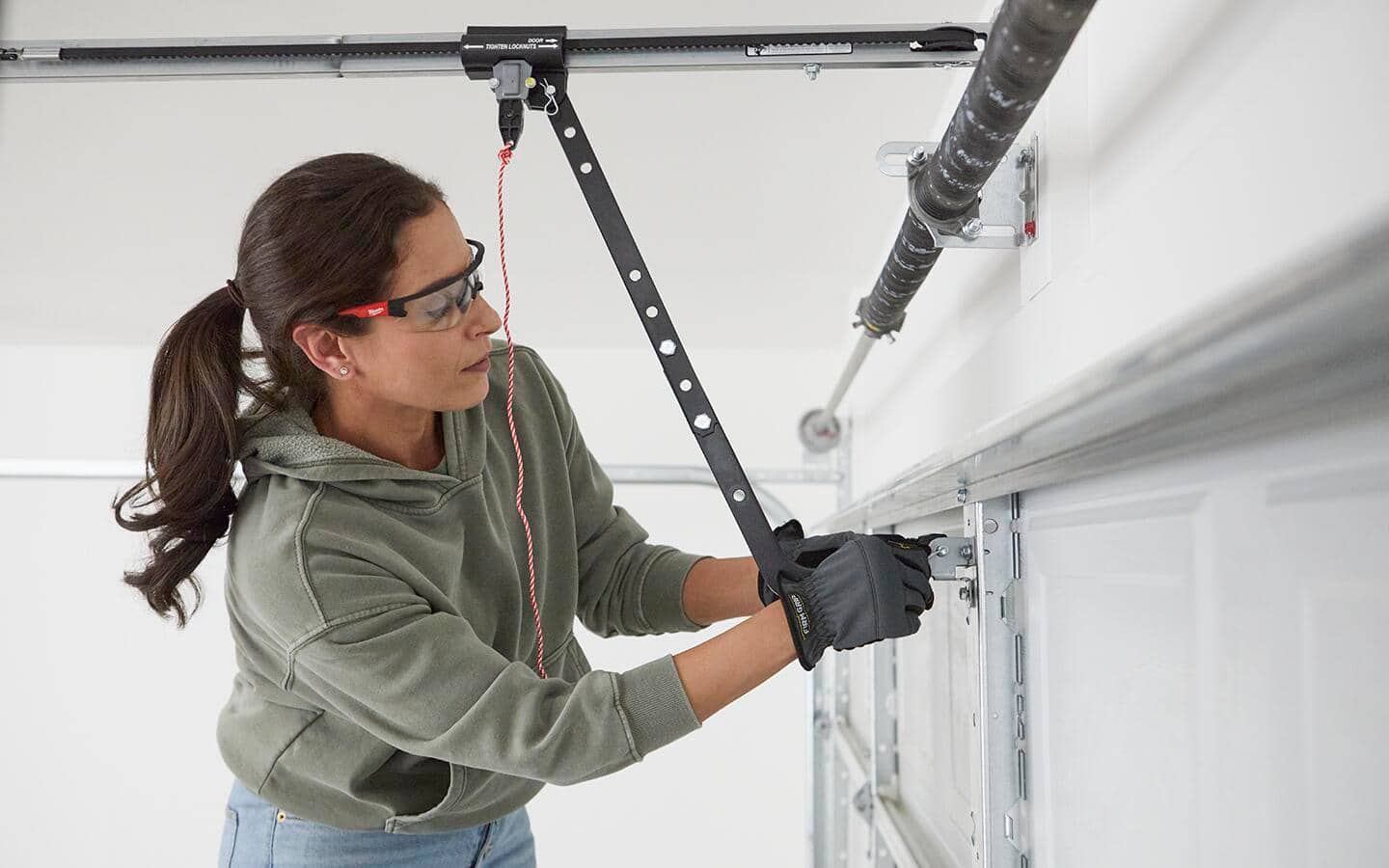 Person attaches the bracket that connects the carriage arm of a smart garage door opener