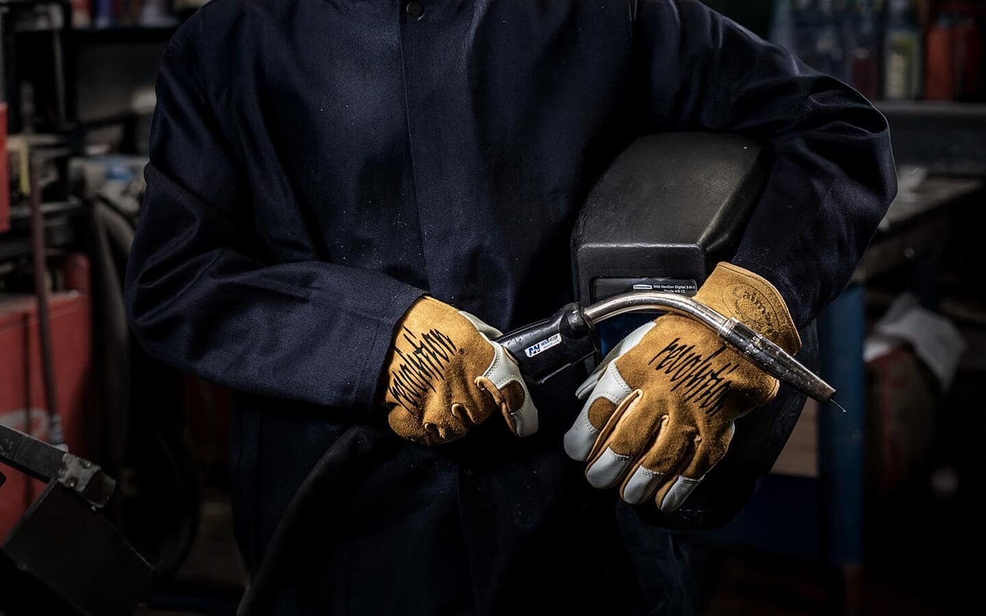 A welder wearing leather work gloves.