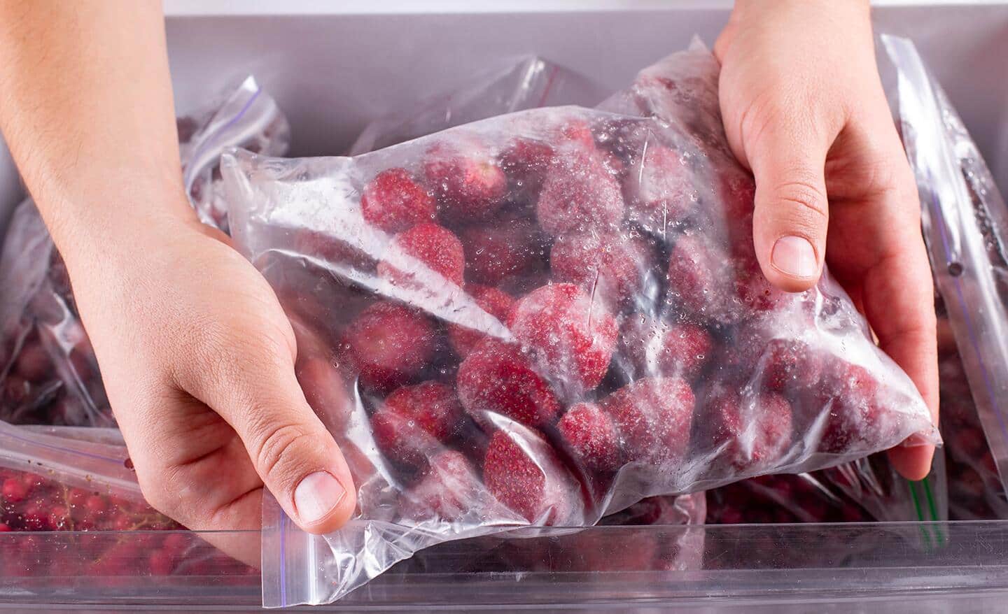 A person holds a bag of frozen berries