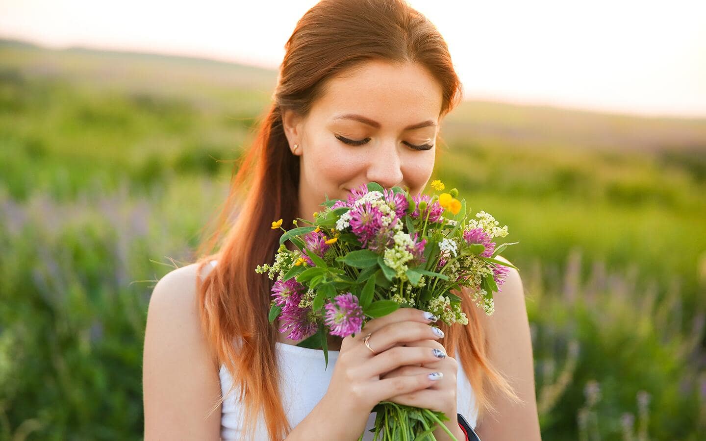 Woman admiring a bouquet of wildflowers.