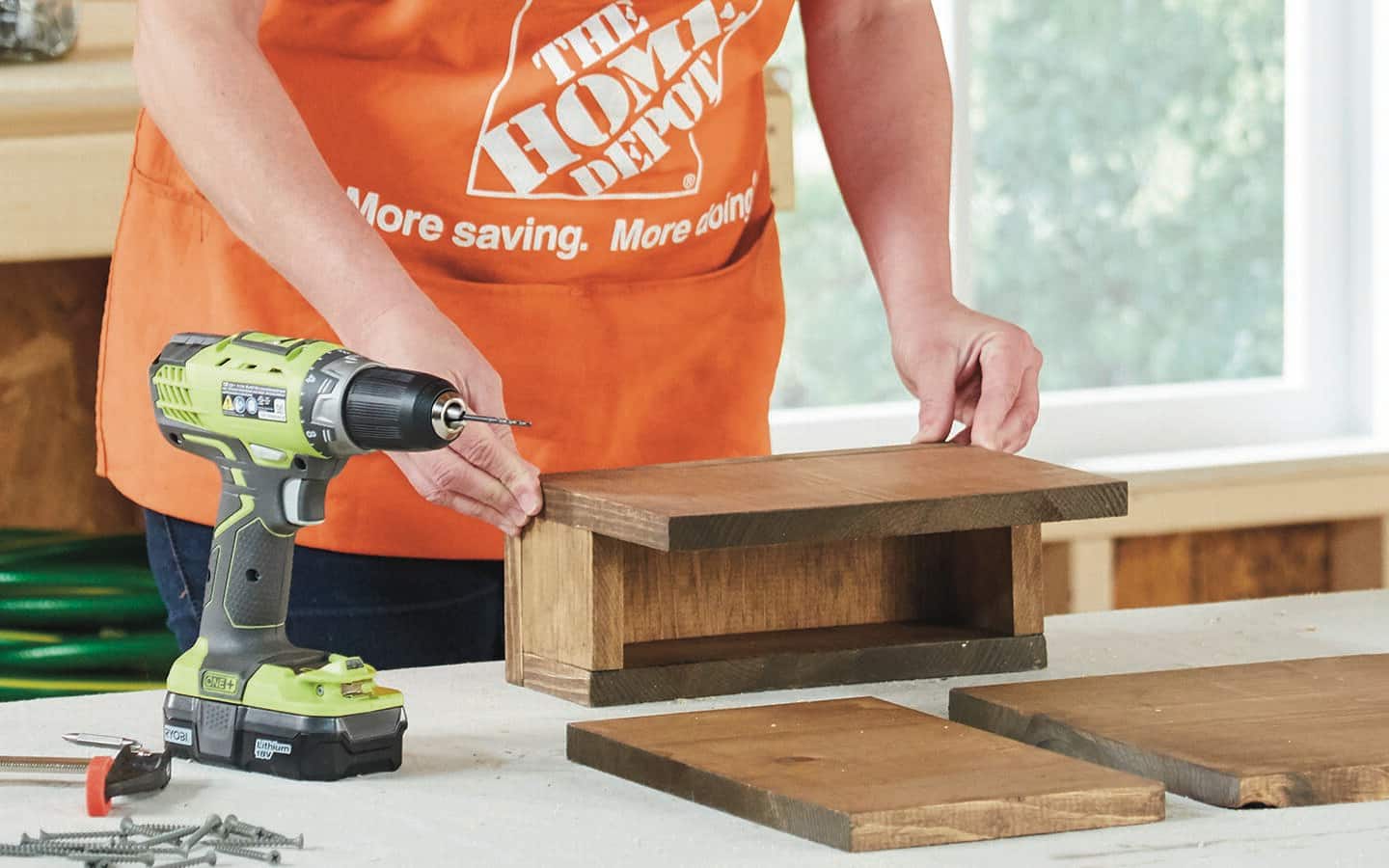 A Home Depot representative assembles the box of a sofa table.