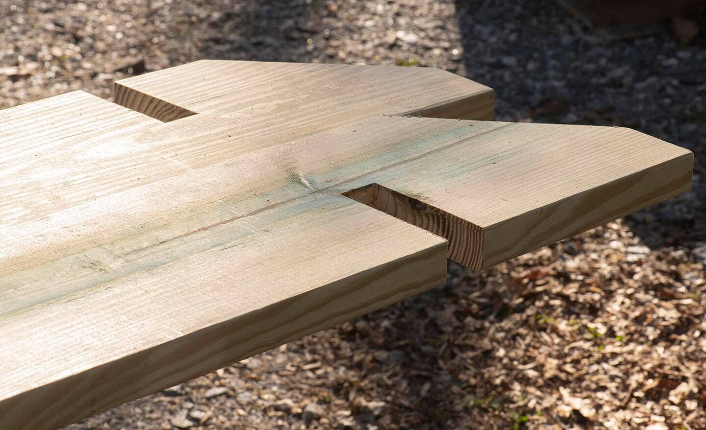 Two 2x10 boards with notches and angles, showing how they should be oriented for building the pergola.