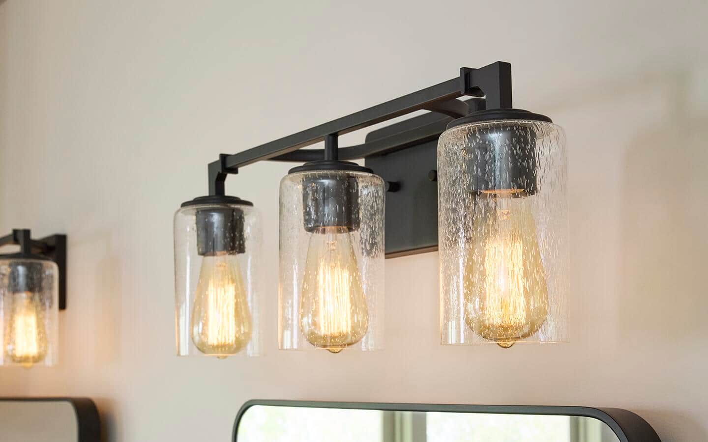 A matte black light bar installed over a vanity mirror. A matte black light bar installed over a vanity mirror.