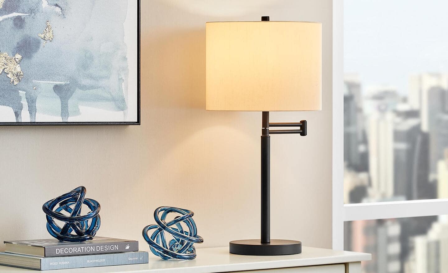 A swing-arm table lamp sits on a white desk.