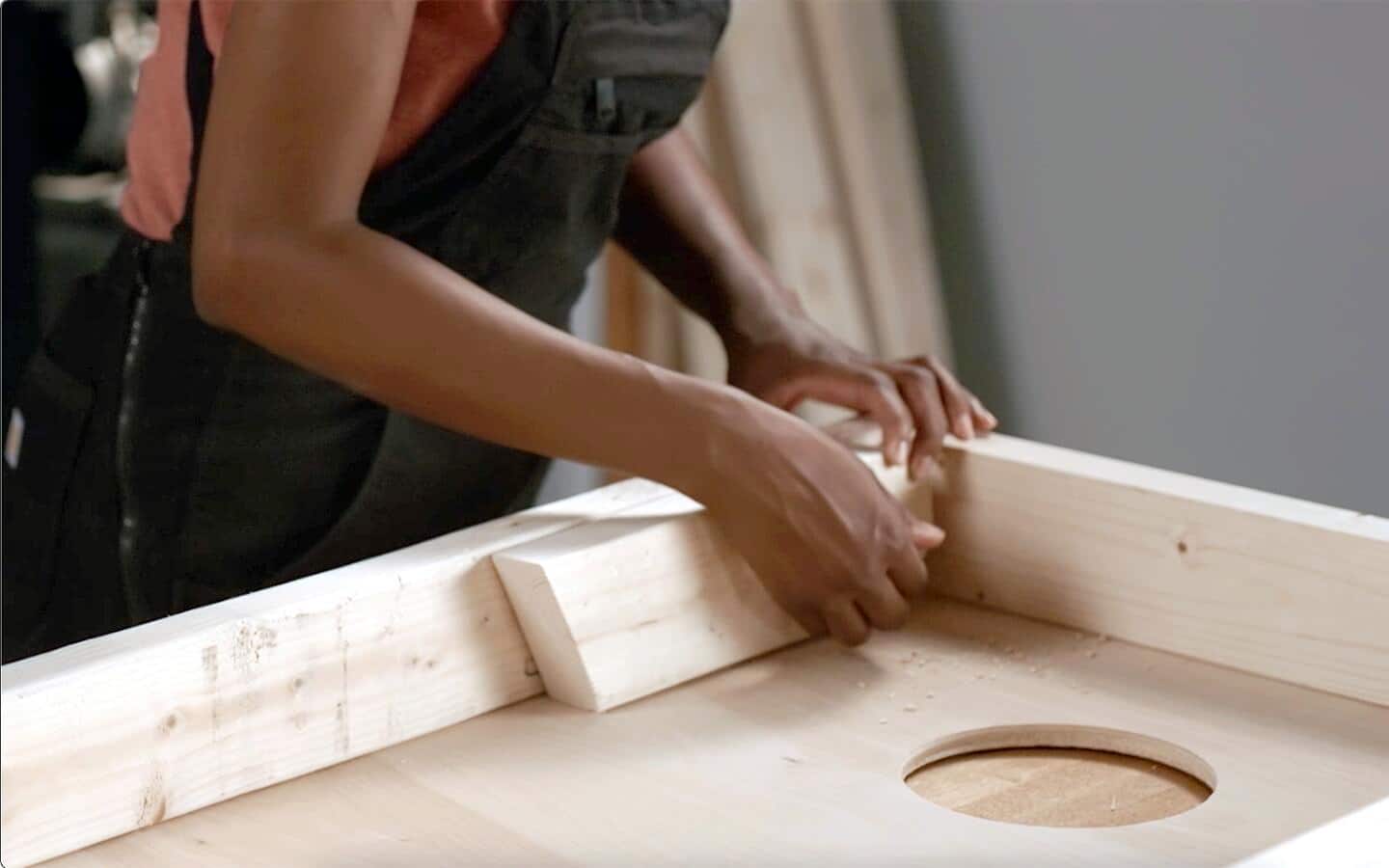 Someone attaching a leg to a DIY cornhole game board. Someone attaching a leg to a DIY cornhole game board.