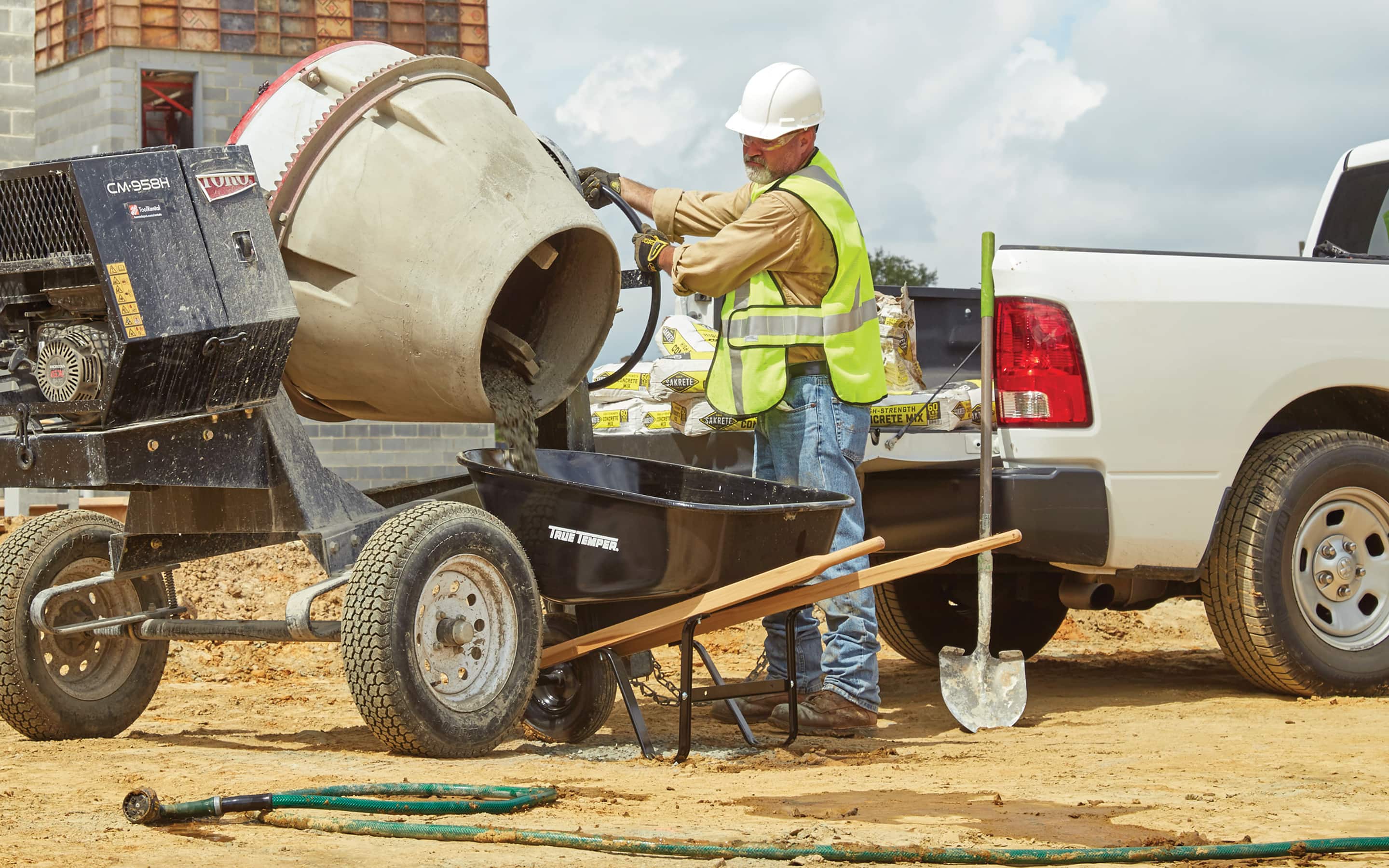A Pro loading concrete into a wheelbarrow. A Pro loading concrete into a wheelbarrow.