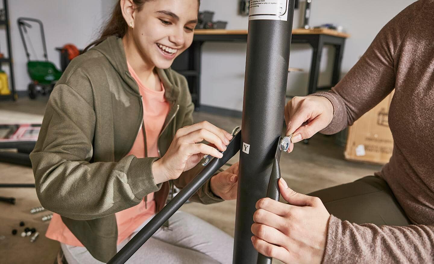 Mom and daughter attach support braces to the bottom hoop pole.