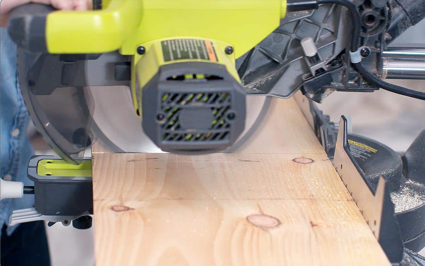 Close up photo of a board being cut on a sliding miter saw. Close up photo of a board being cut on a sliding miter saw.
