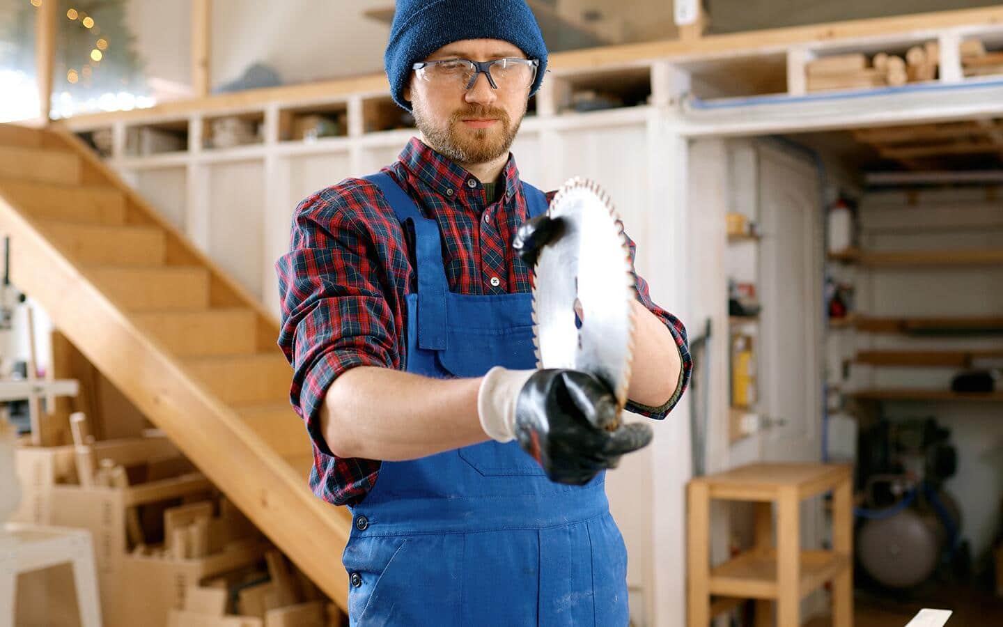 A man inspects a saw blade as part of a tool maintenance routine. A man inspects a saw blade as part of a tool maintenance routine.