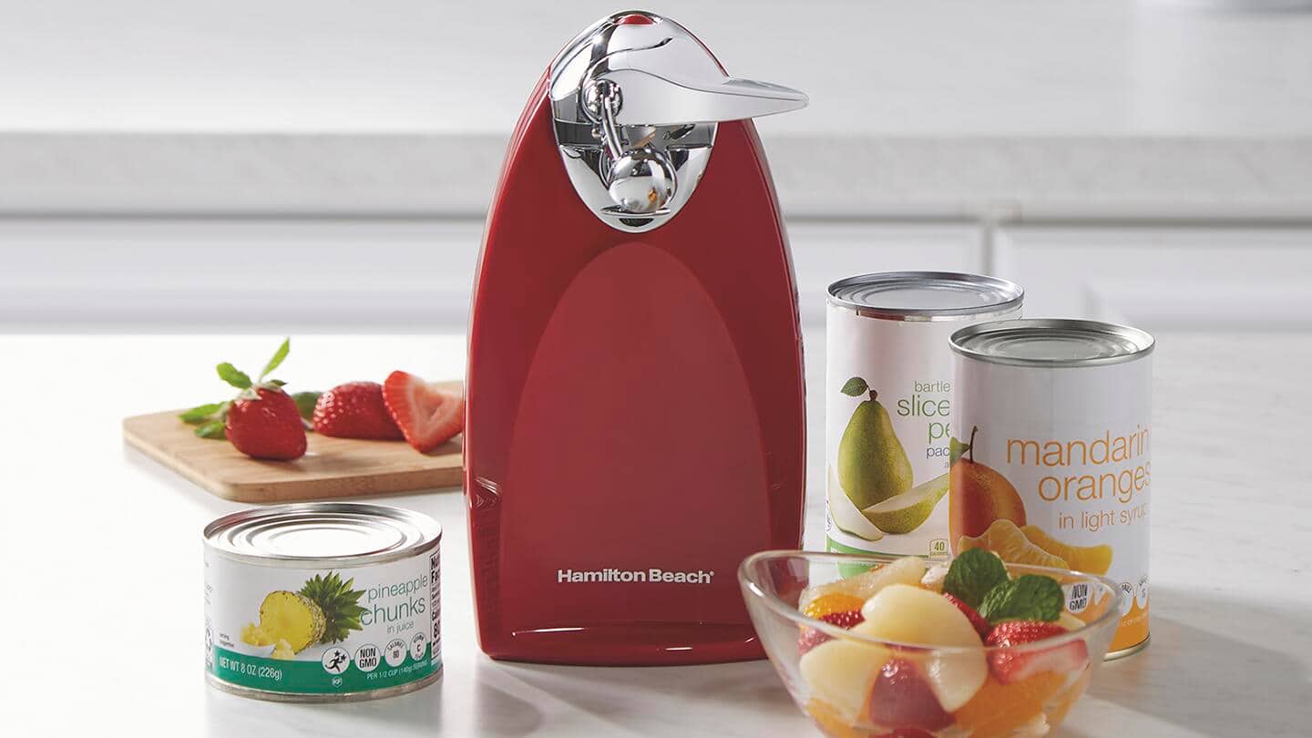 Countertop can opener surrounded by cans. Countertop can opener surrounded by cans.