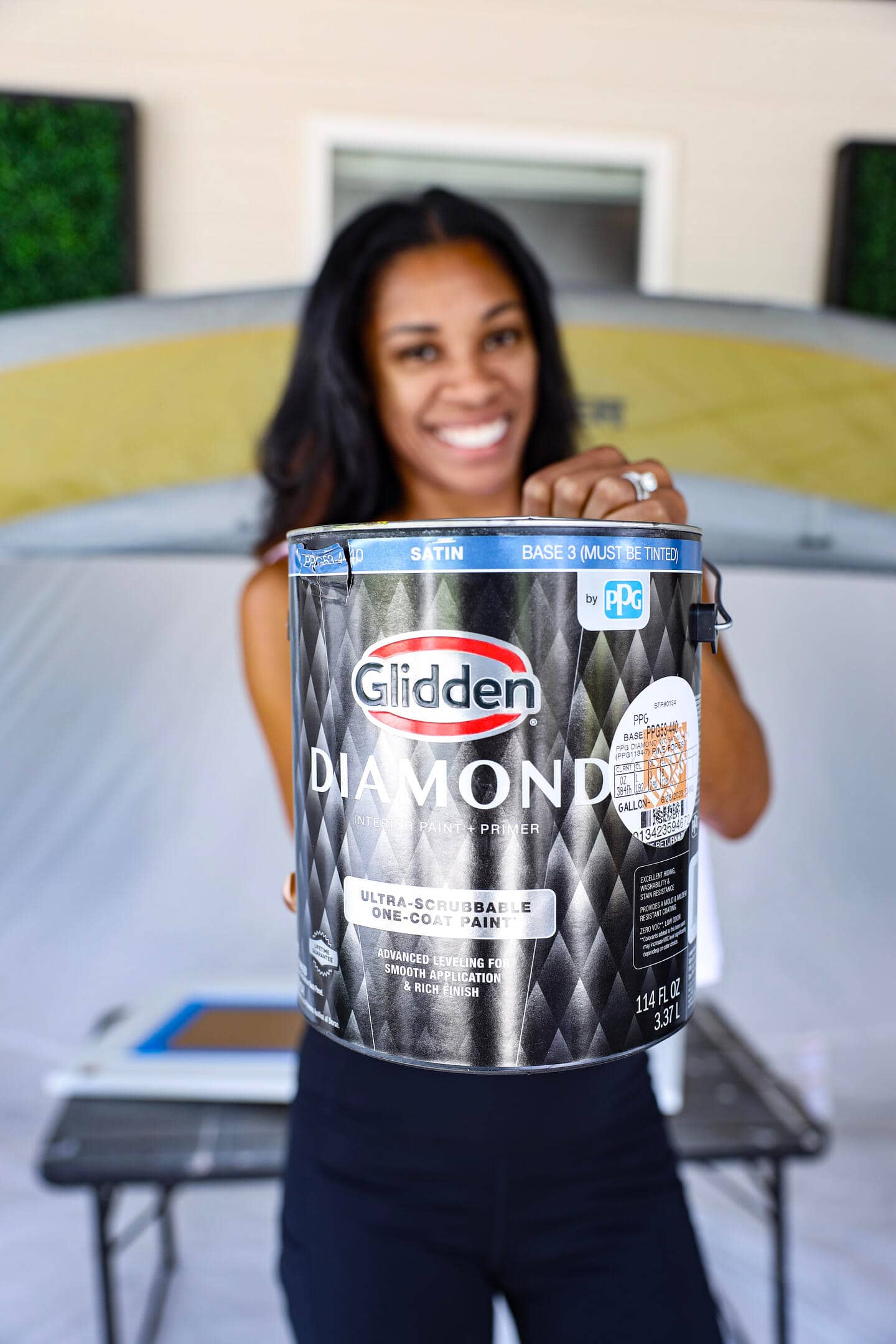 Focused shot of a woman holding a can of Glidden Diamond paint