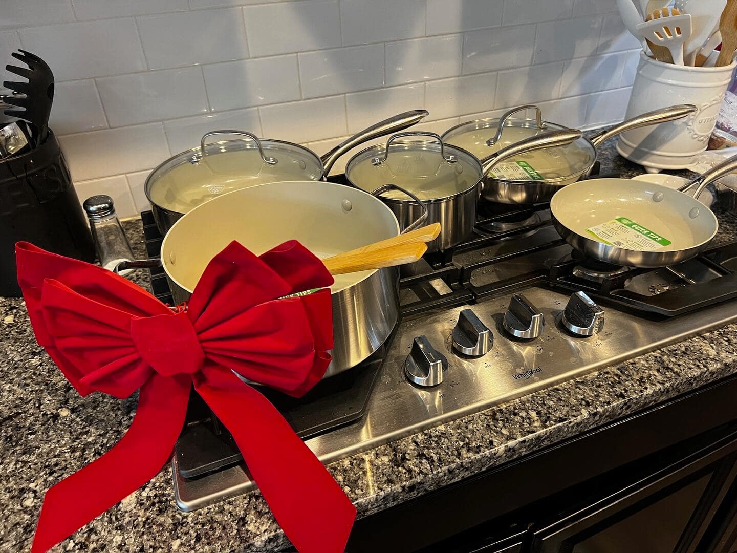 Stainless steel cookware set with a red velvet bow.