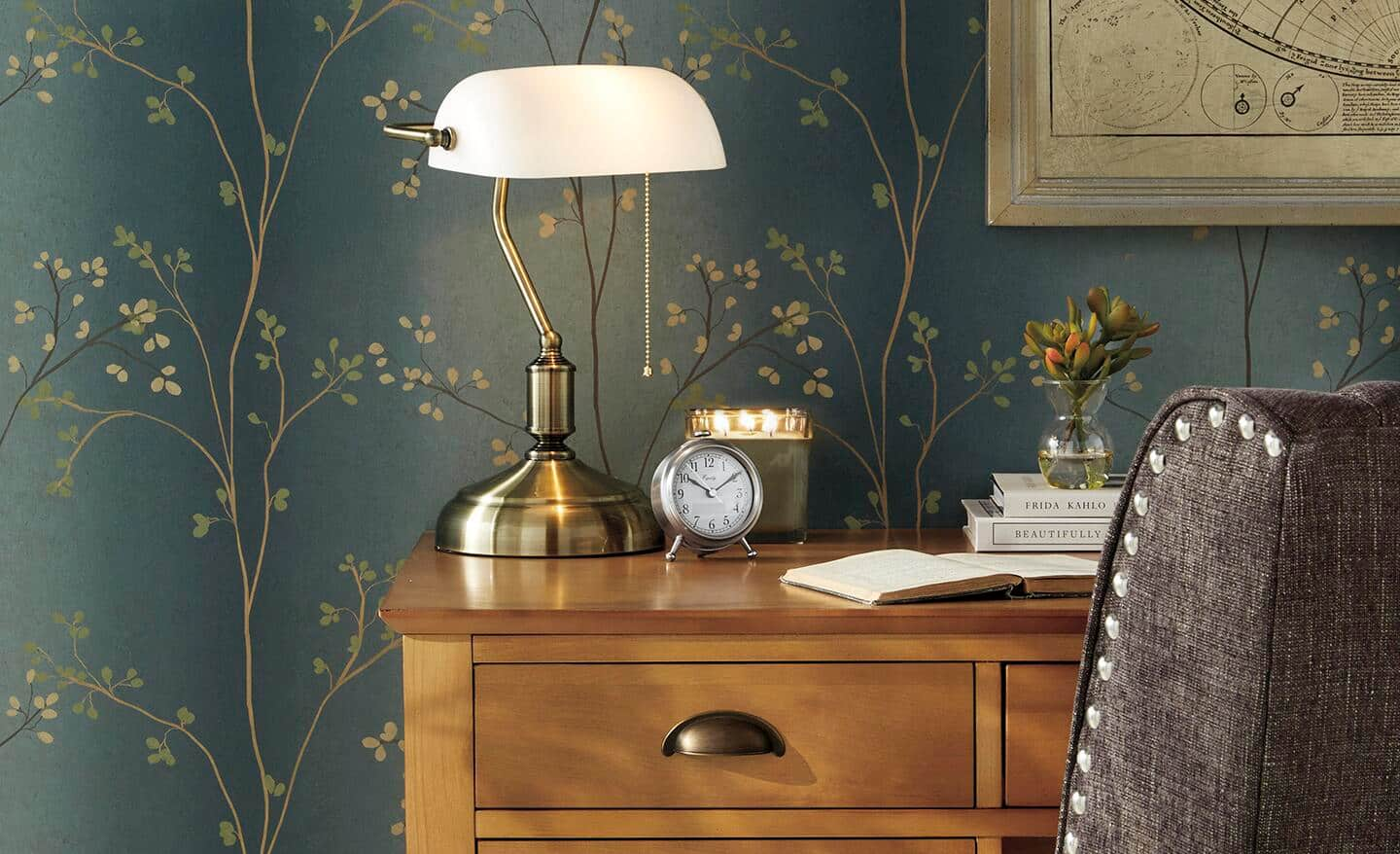 A banker lamp sits on a desk in a home office.