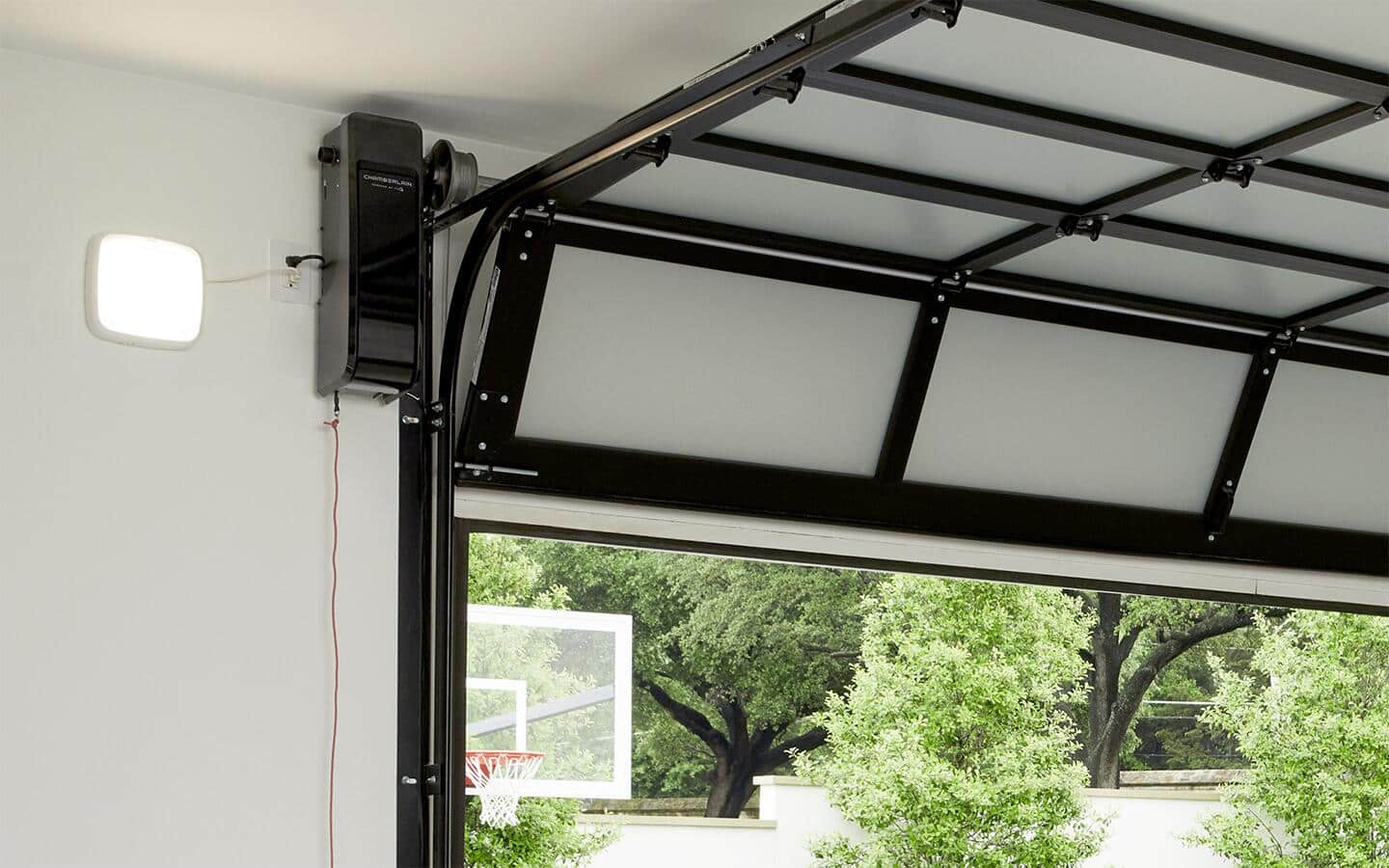 A wall mount garage door opener hangs on a garage wall.