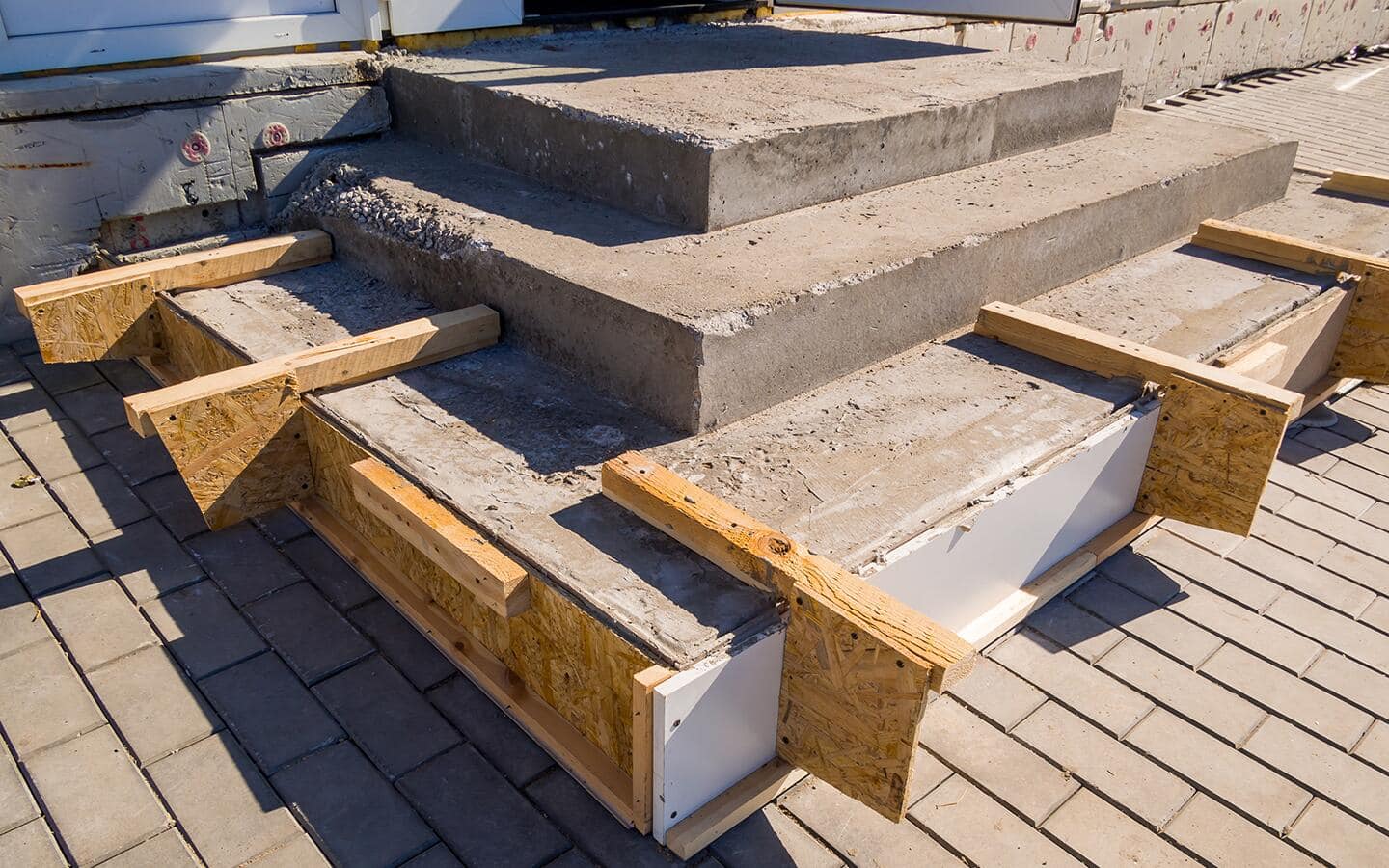 Wooden board forms hold wet concrete steps in place as the material dries. Wooden board forms hold wet concrete steps in place as the material dries.