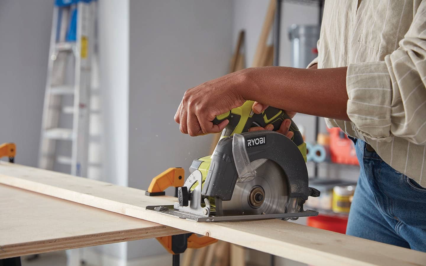 A person uses a circular saw to cut wood for a DIY coat hanger.