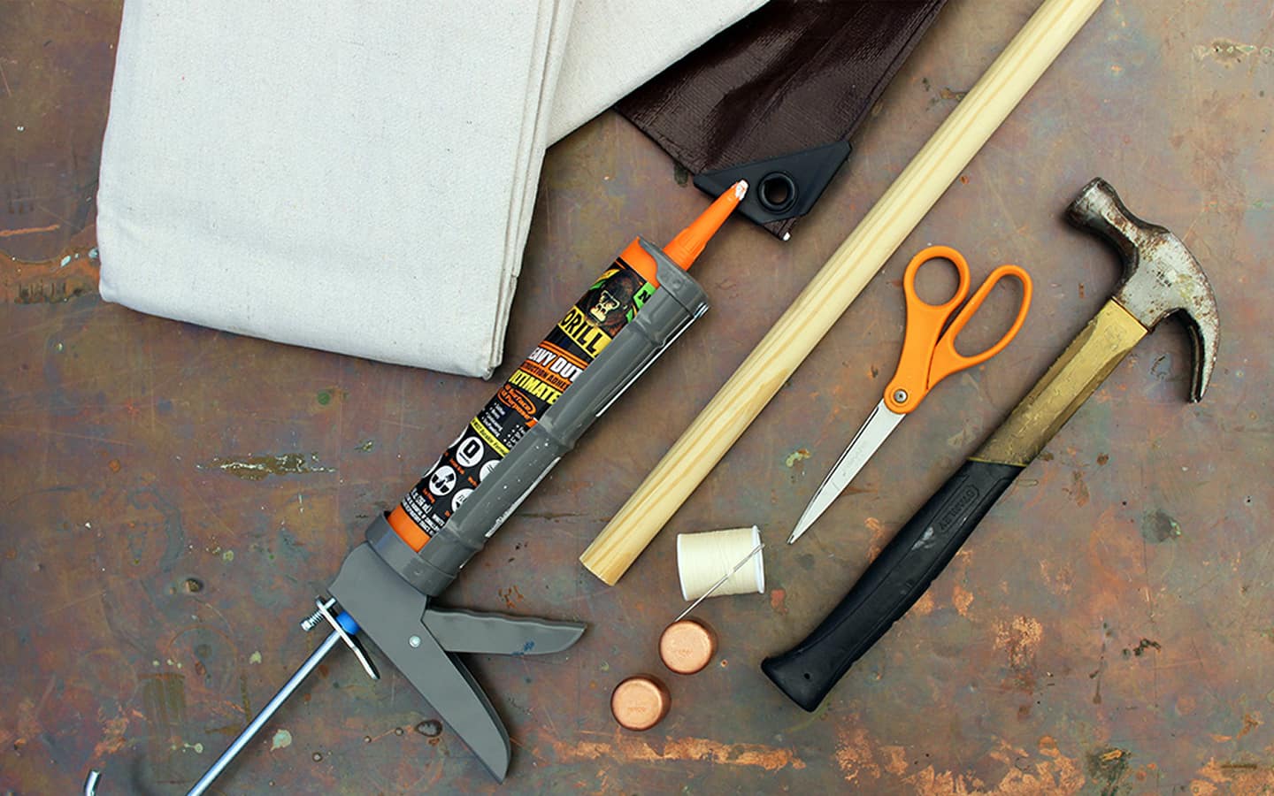 A hammer, scissors, caulk gun and various materials needed to make an outdoor projection screen.