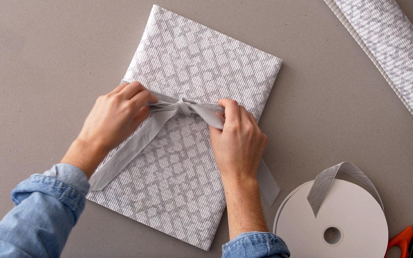 A finished envelope is wrapped in a grey velvet bow.