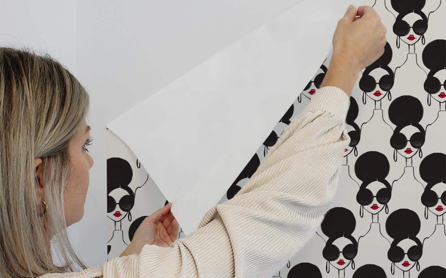 A person peels wallpaper from a wall. A person peels wallpaper from a wall.