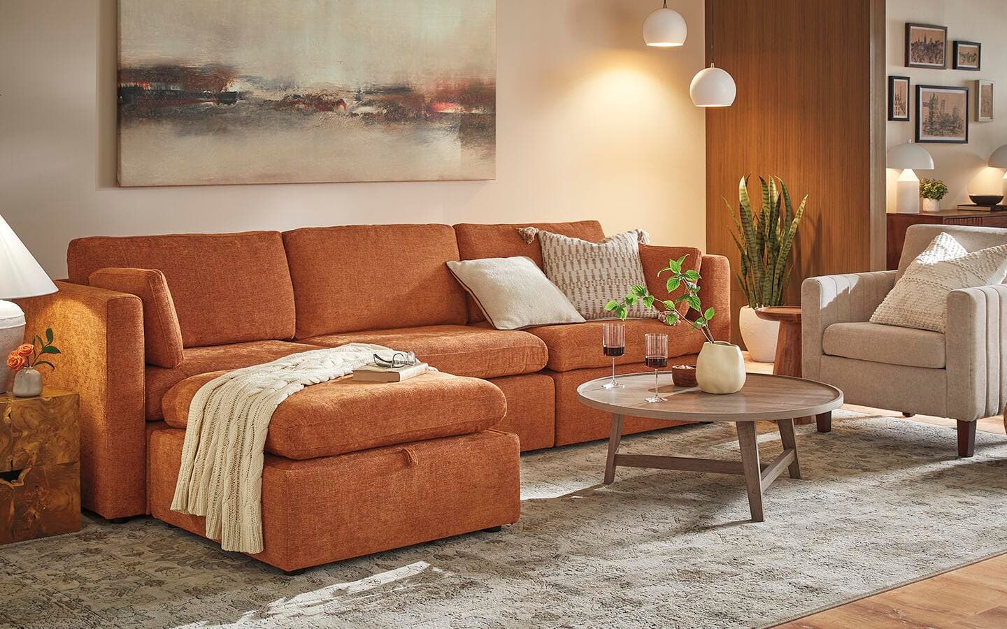 An orange track-arm couch placed against a wall in a living room. An orange track-arm couch placed against a wall in a living room.