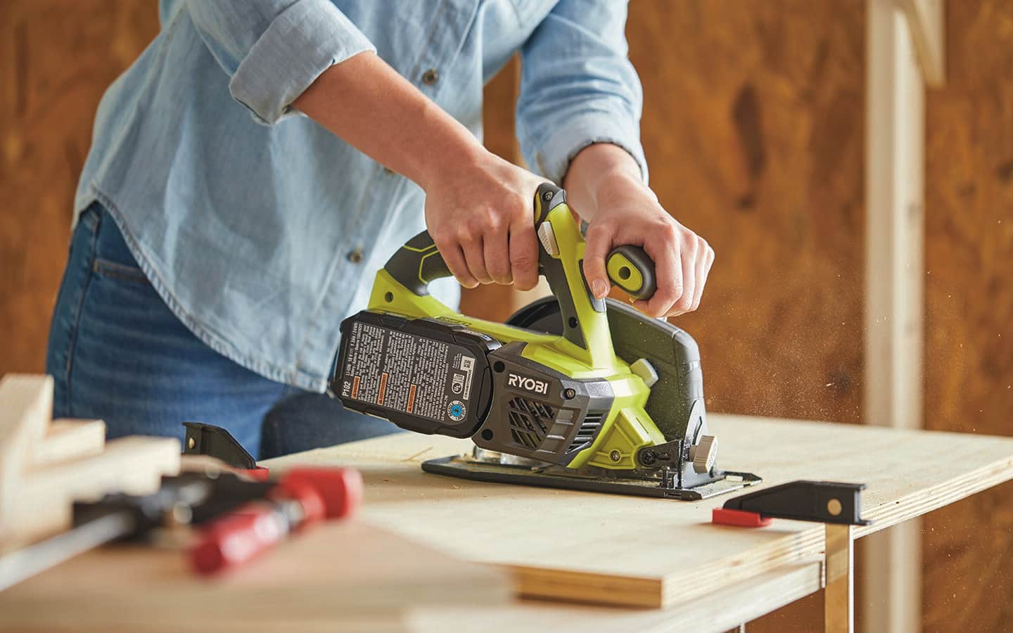 A person using a circular saw to cut plywood. A person using a circular saw to cut plywood.